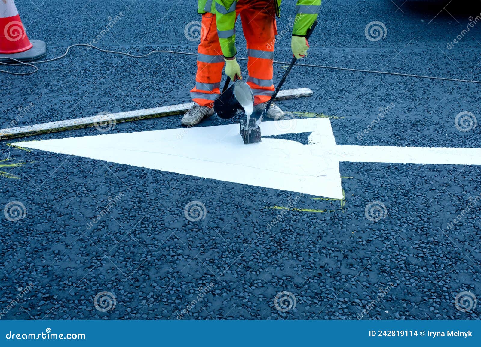 roadworker painting road marking on new-laid asphalt surface during road improvements works