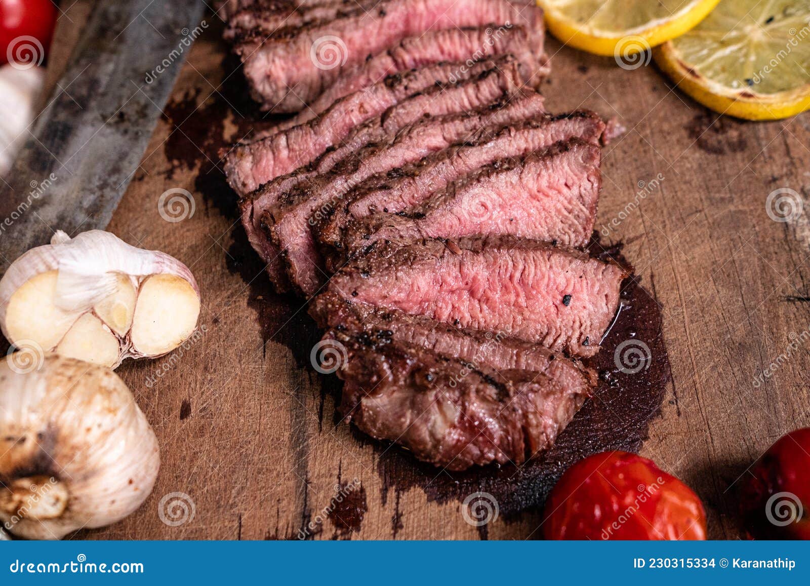 Roast Beef on Cutting Board with Saltcellar Garlic,tomatoes and Lemon