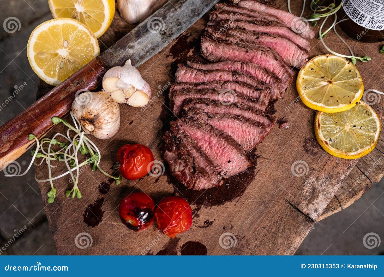 Roast Beef on Cutting Board with Saltcellar Garlic,tomatoes and Lemon