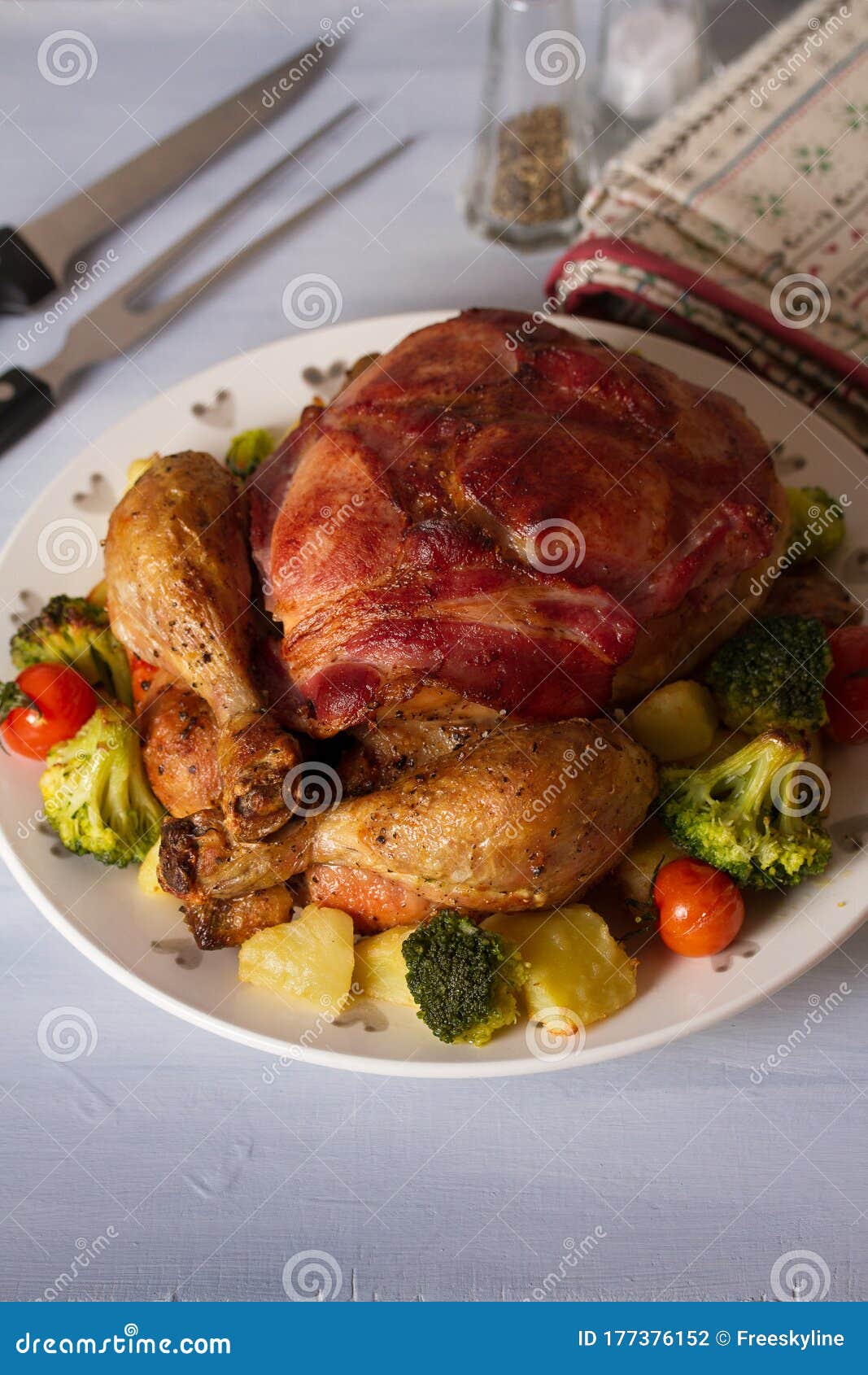 Roast Chicken with Breasts Wrapped in Bacon and Vegetables. Stock Photo