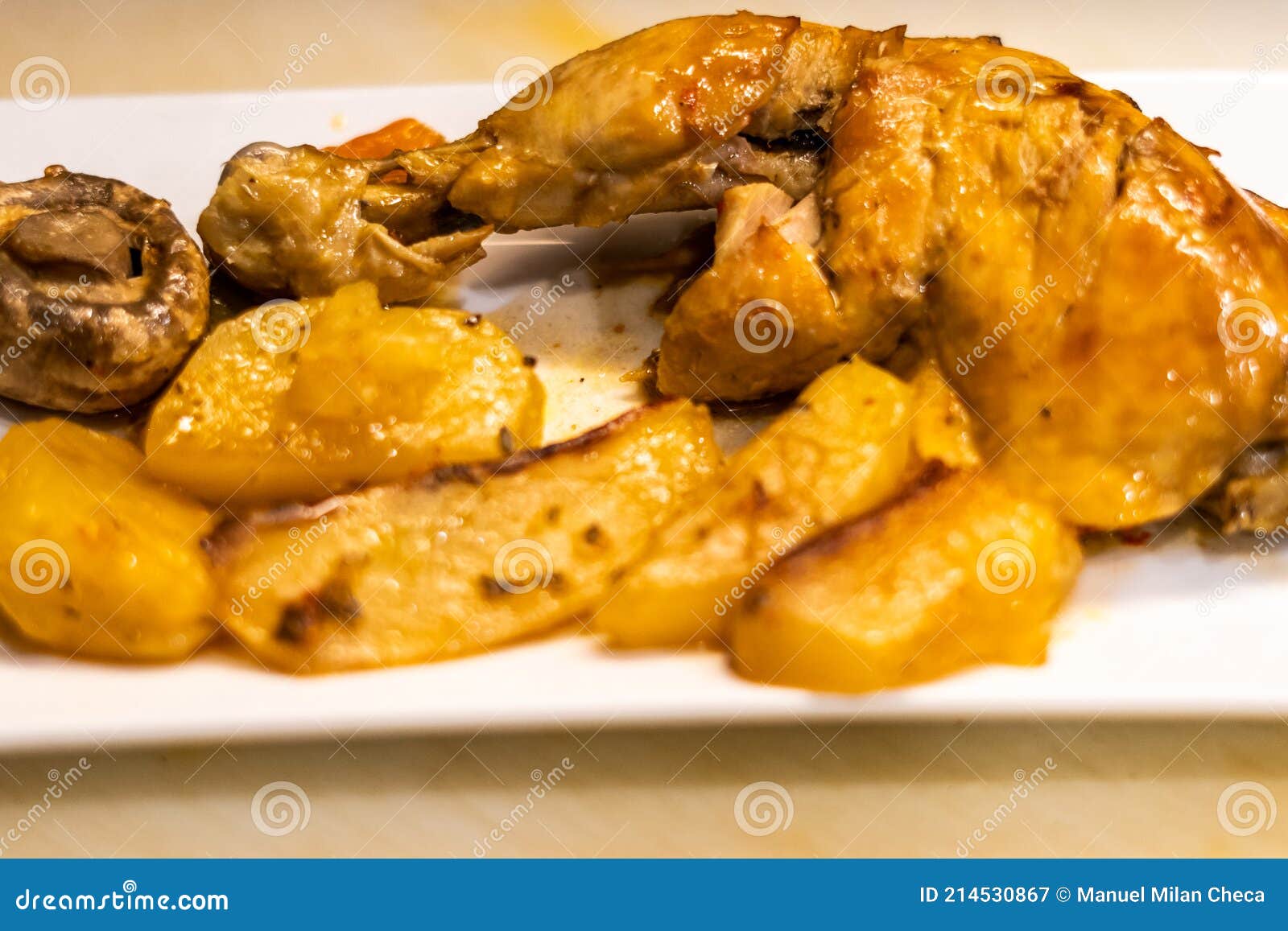 Roast Chicken Thigh with Potatoes and Mushrooms on a White Plate Stock