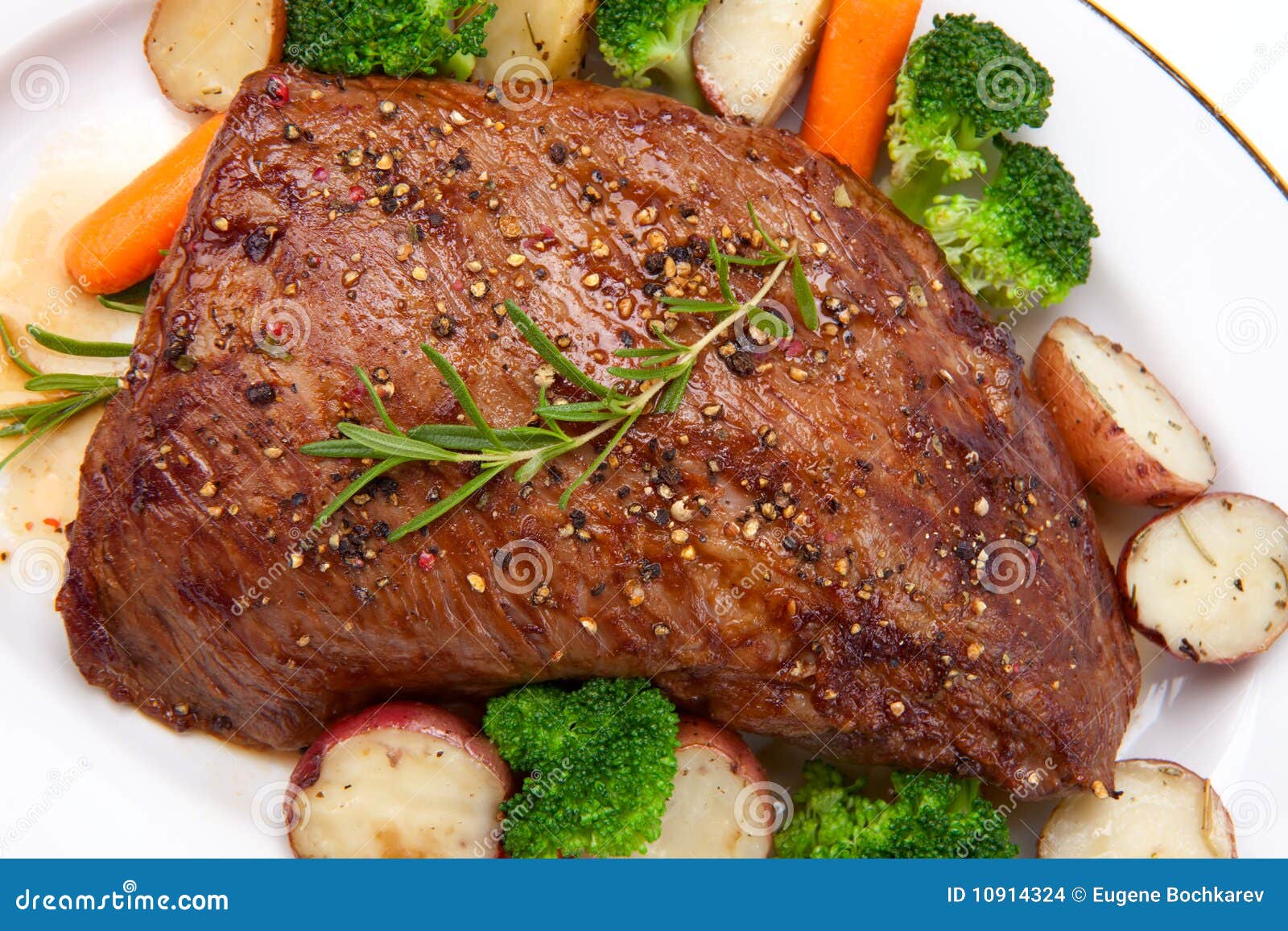Roasted Beef On Platter Next To Fatty Bits And String In Pan Stock
