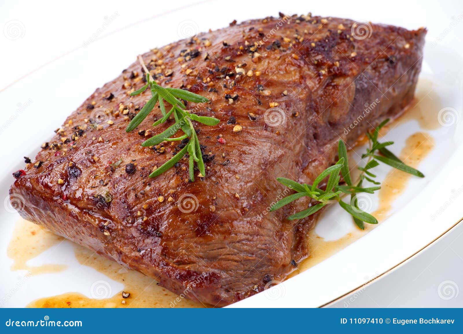 Roasted Beef On Platter Next To Fatty Bits And String In Pan Stock