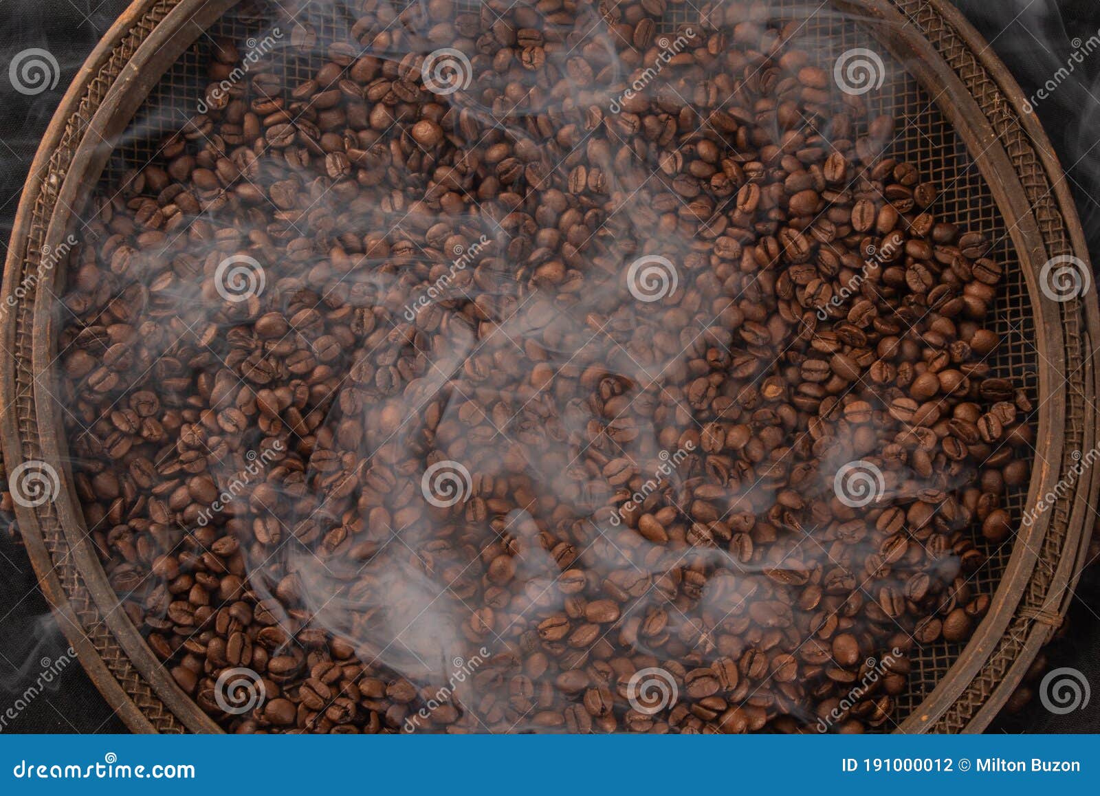 Roasted Coffee on Rustic Sieve with Smoke and with Black Background, Top View Stock Photo