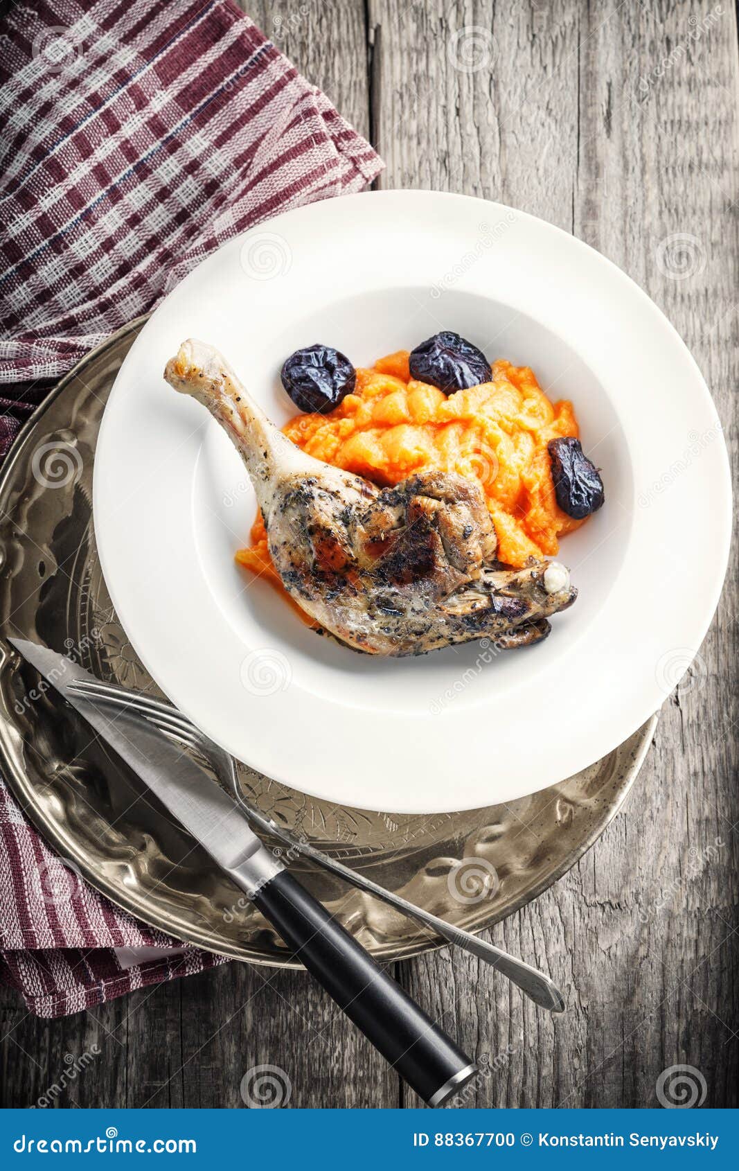 Roasted Duck Leg with Mashed Carrot and Dried Prunes Stock Photo