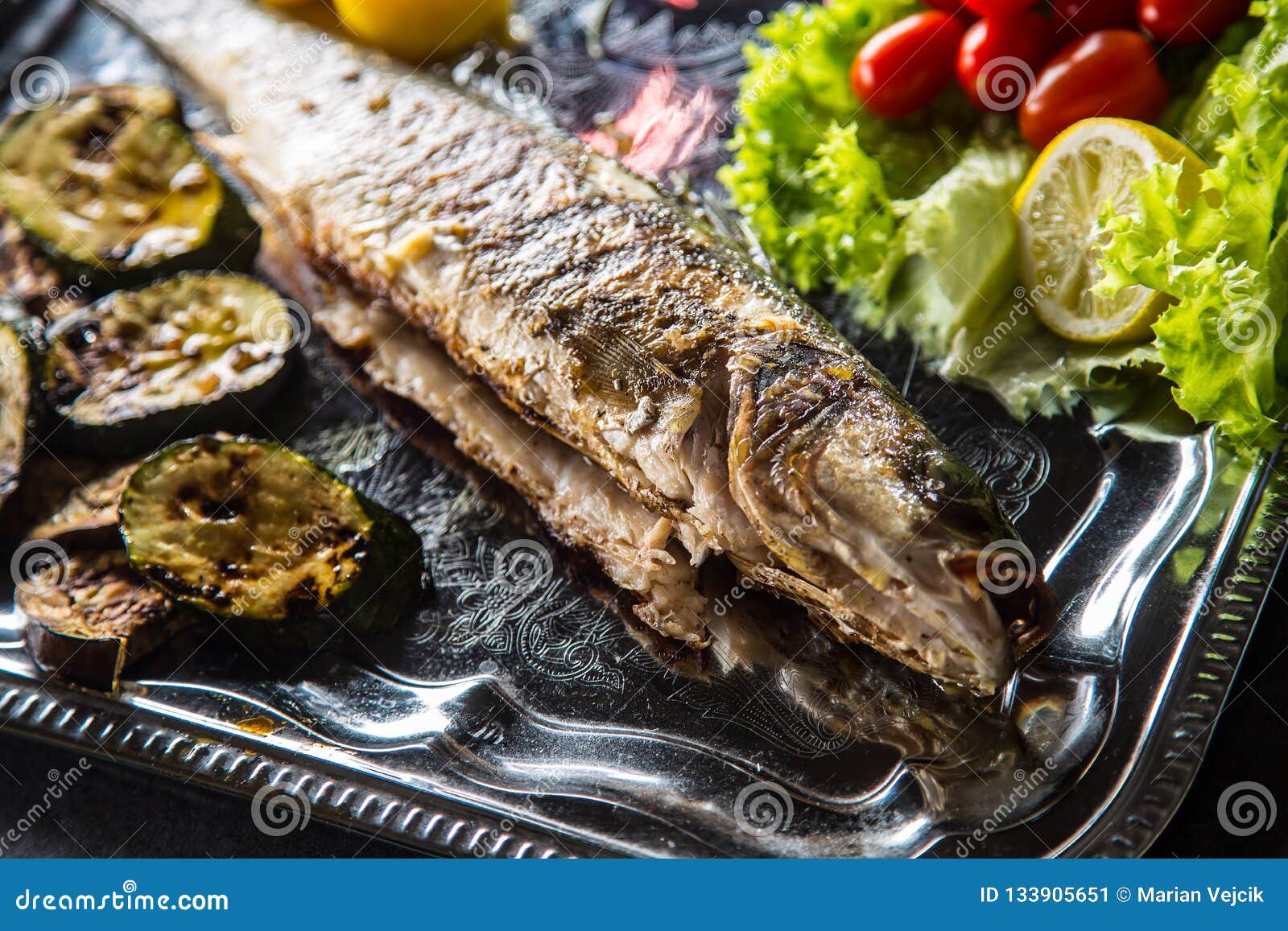 Roasted Fish on Dish with Fresh and Grilled Vegetable Stock Image