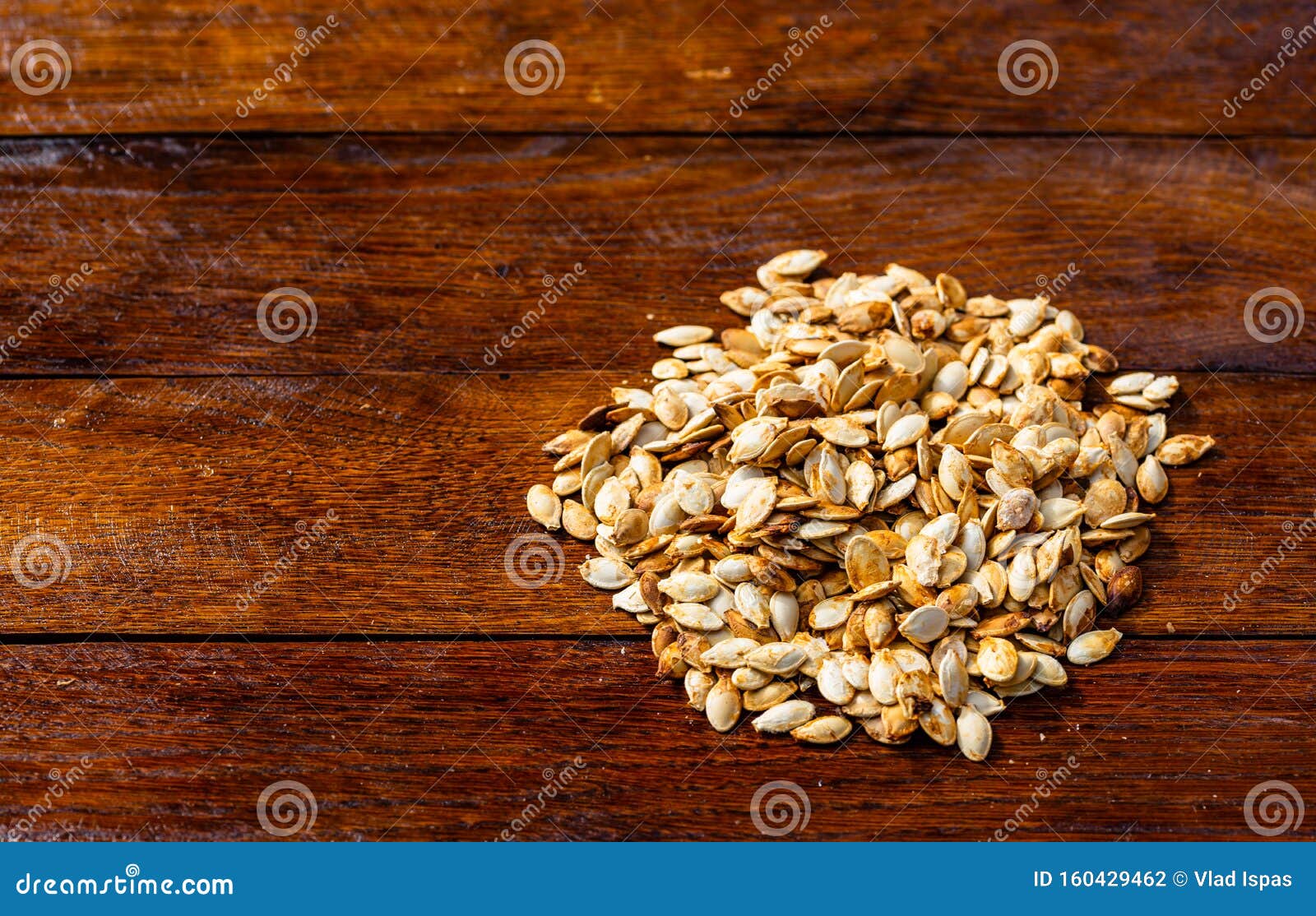 Roasted and Salted Pumpkin Seeds on a Wooden Board Stock Photo Image