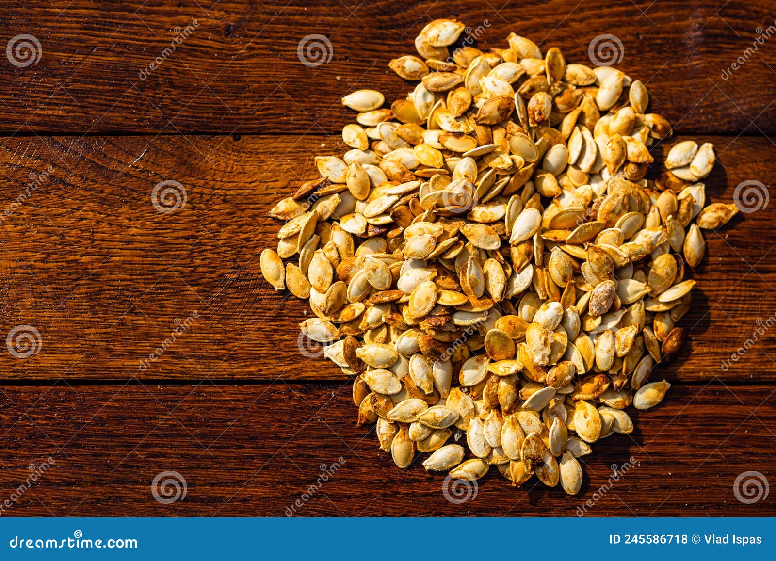 Roasted and Salted Pumpkin Seeds on a Wooden Board Stock Photo Image