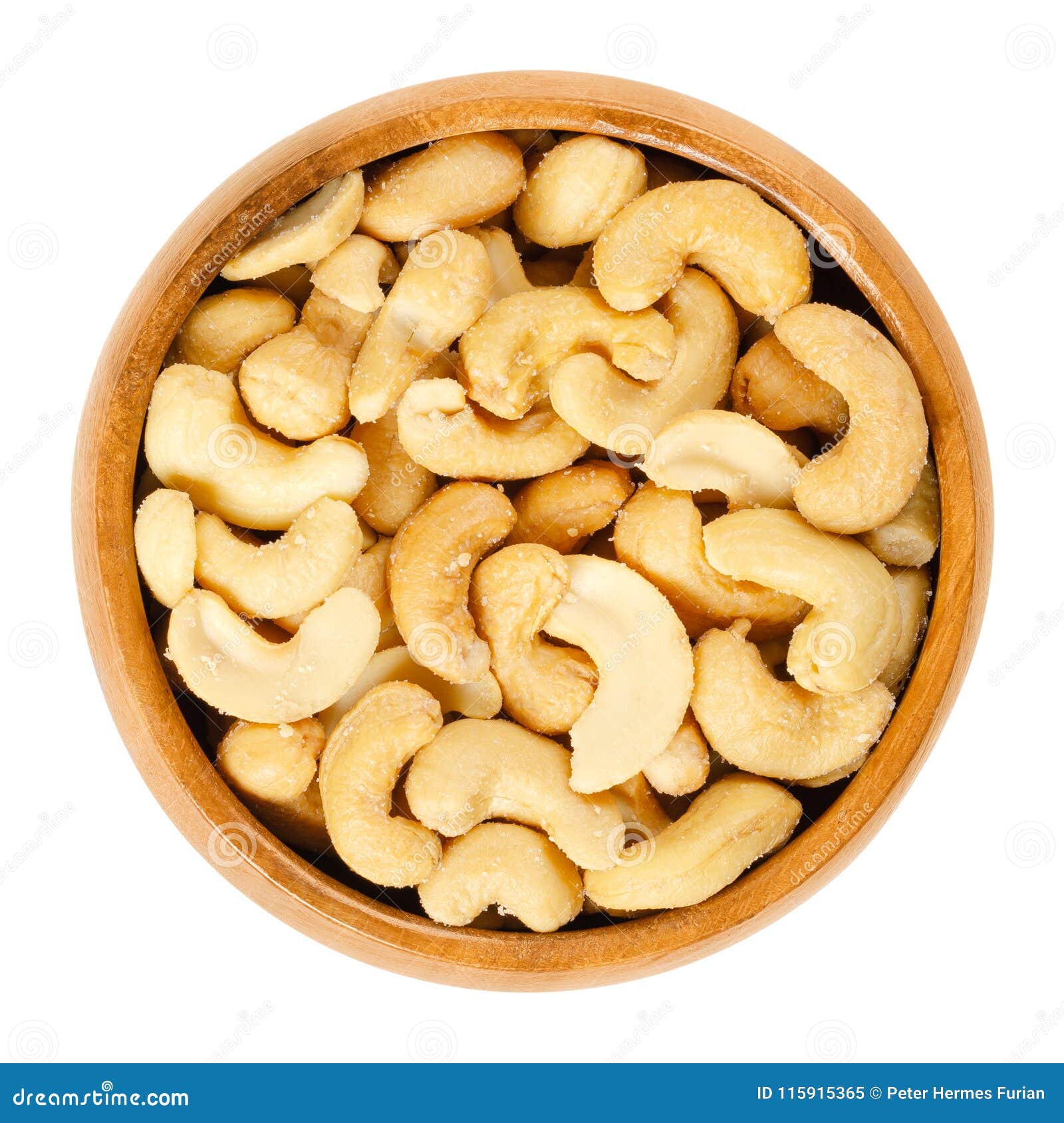roasted salted whole cashews in wooden bowl over white