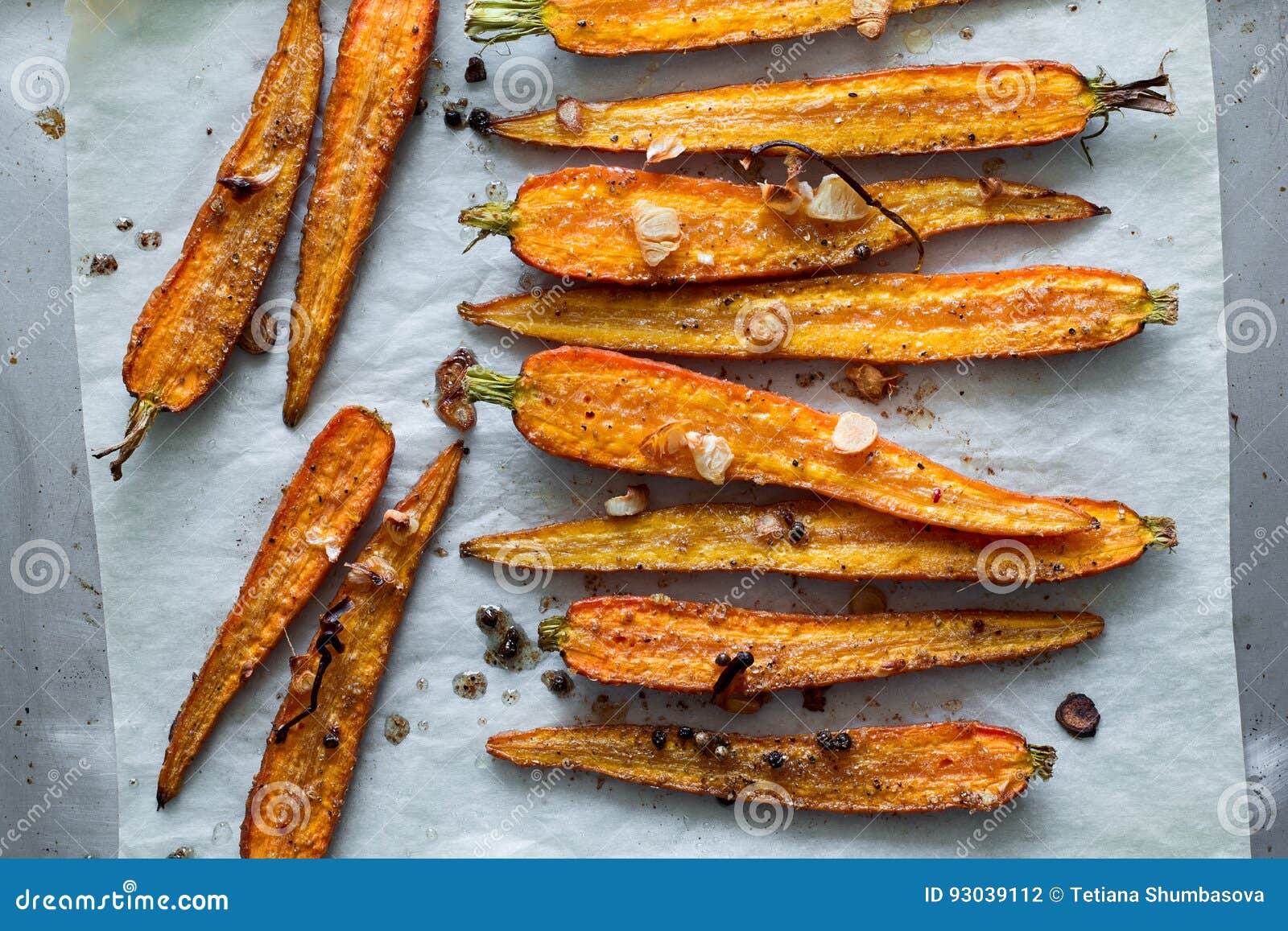 Roasted Spring Carrots on Parchment with Garlic, Pepper Peas and Coriander Stock Photo Image