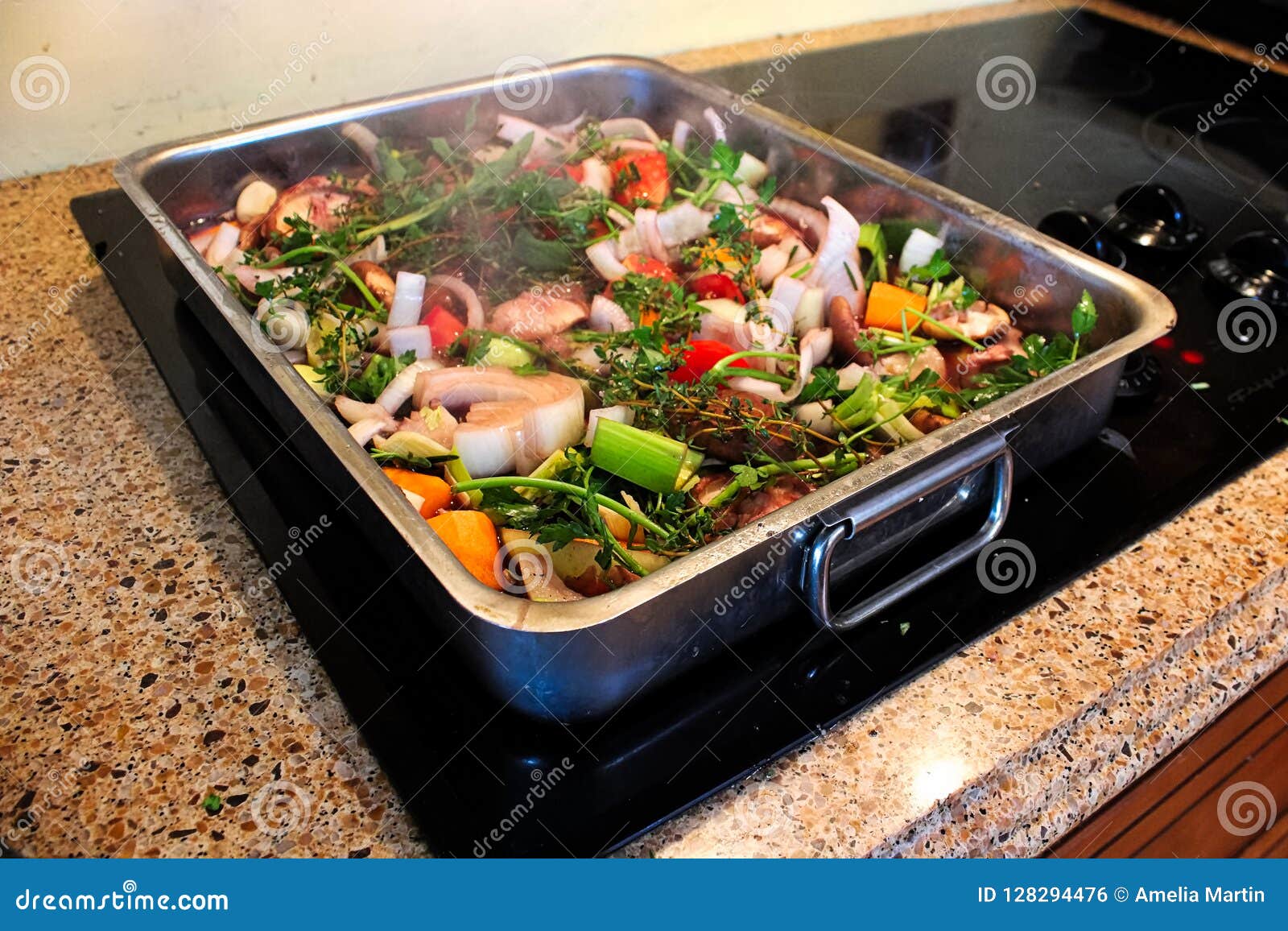 A Roasting Pan Full of Vegetables and Herbs Steaming Stock Photo