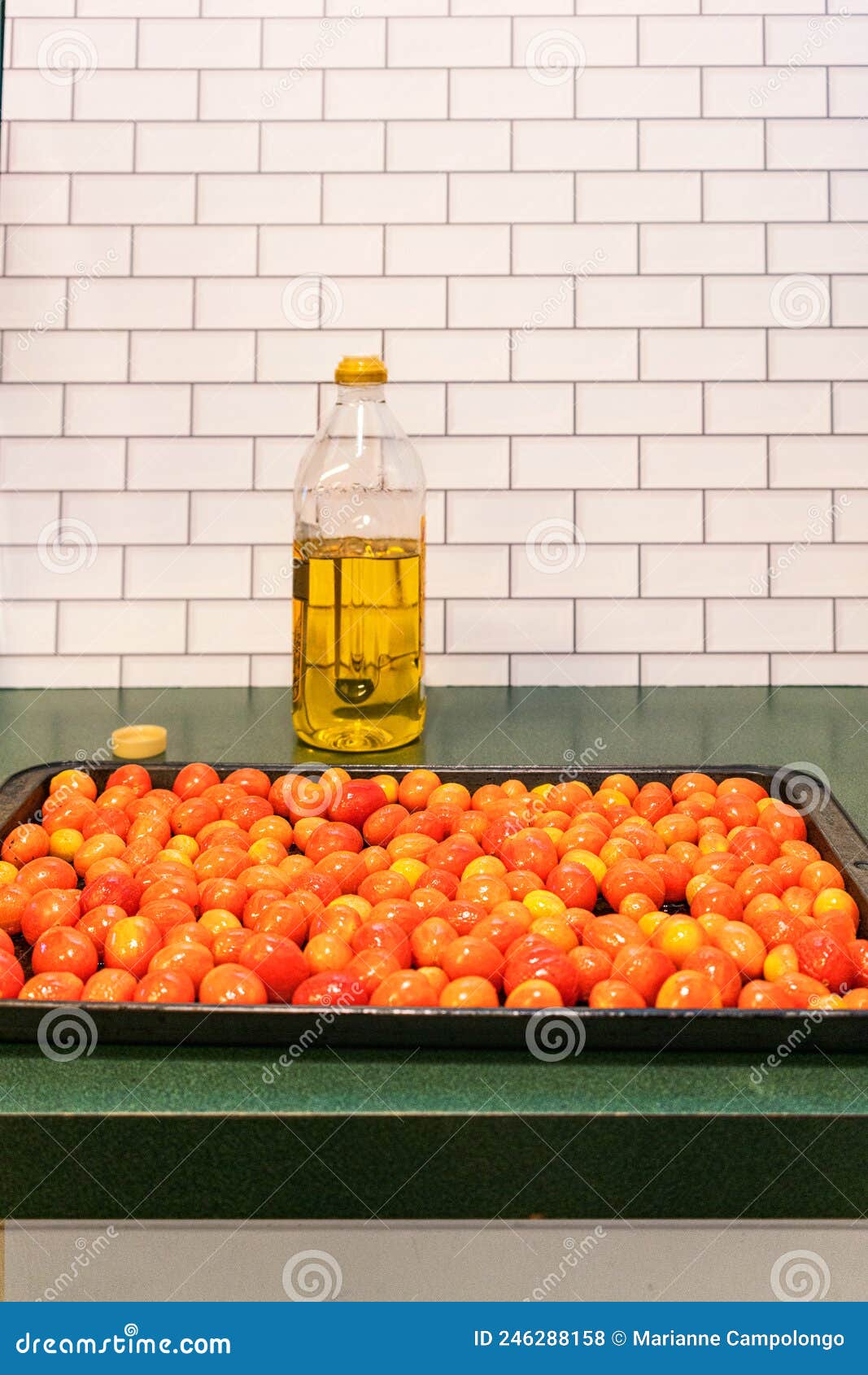 roasting pan with `a grappoli d`inverno` winter grape tomatoes and a bottle of italian olive oil