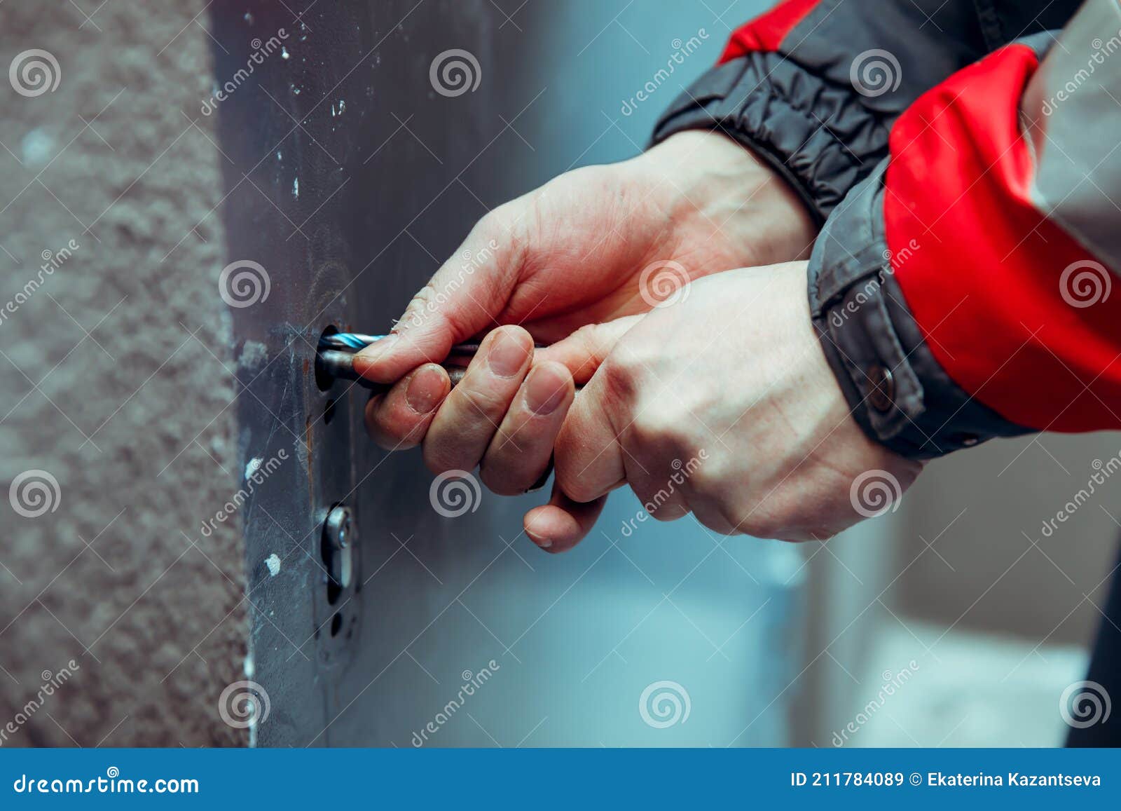 the robber thief breaks open the front metal door with pickpockets - improvised tools.
