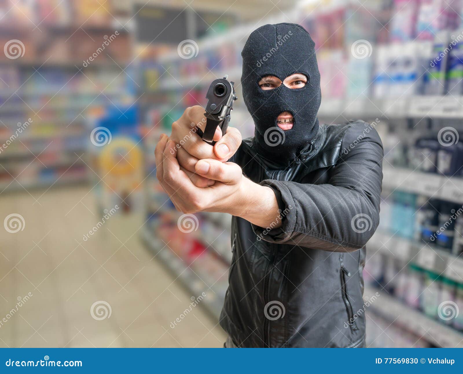 robbery in store. robber is aiming and threatening with gun in shop