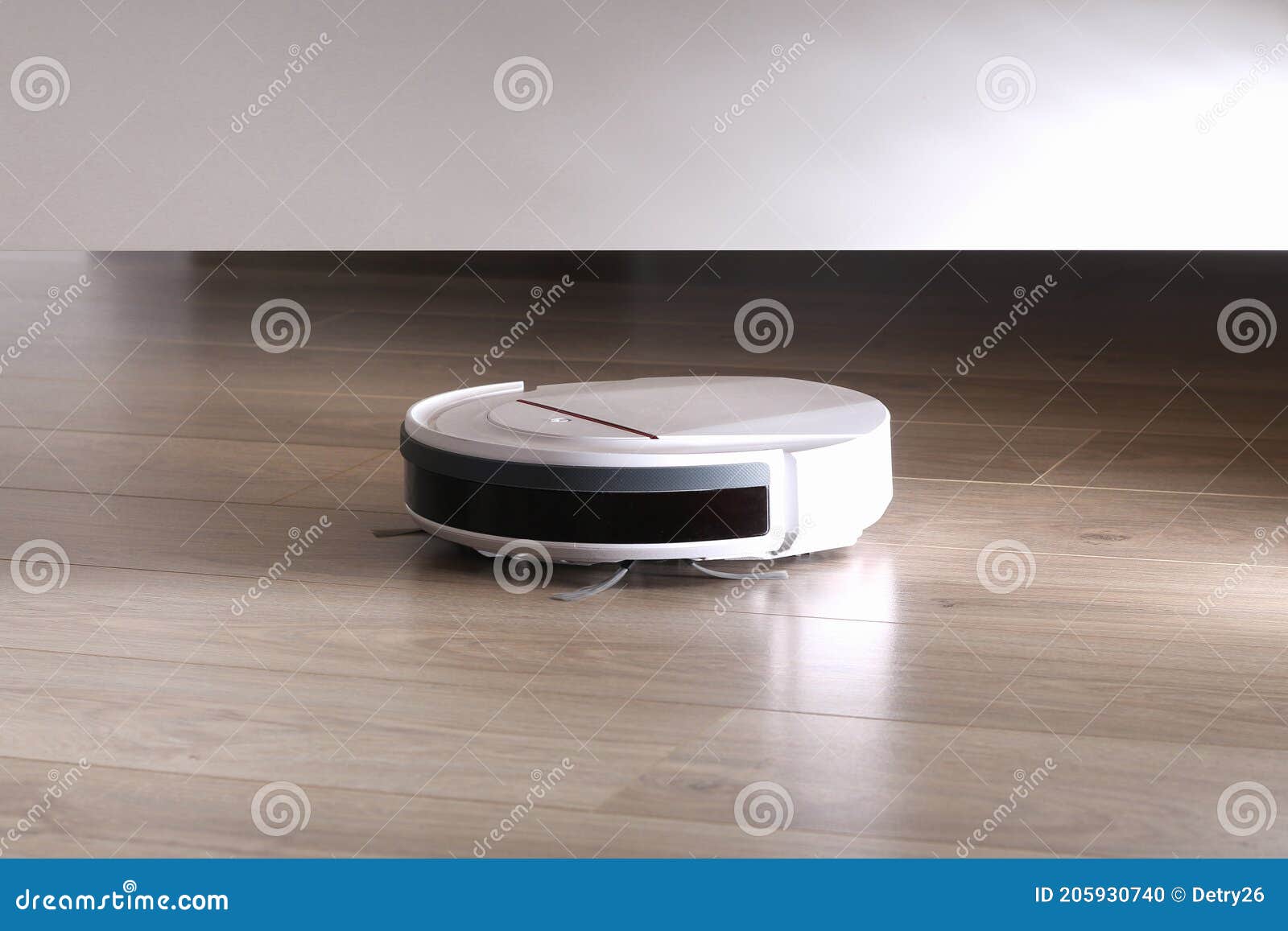 The Robot Vacuum Cleaner Cleans Under Bed. Stock Photo Image of