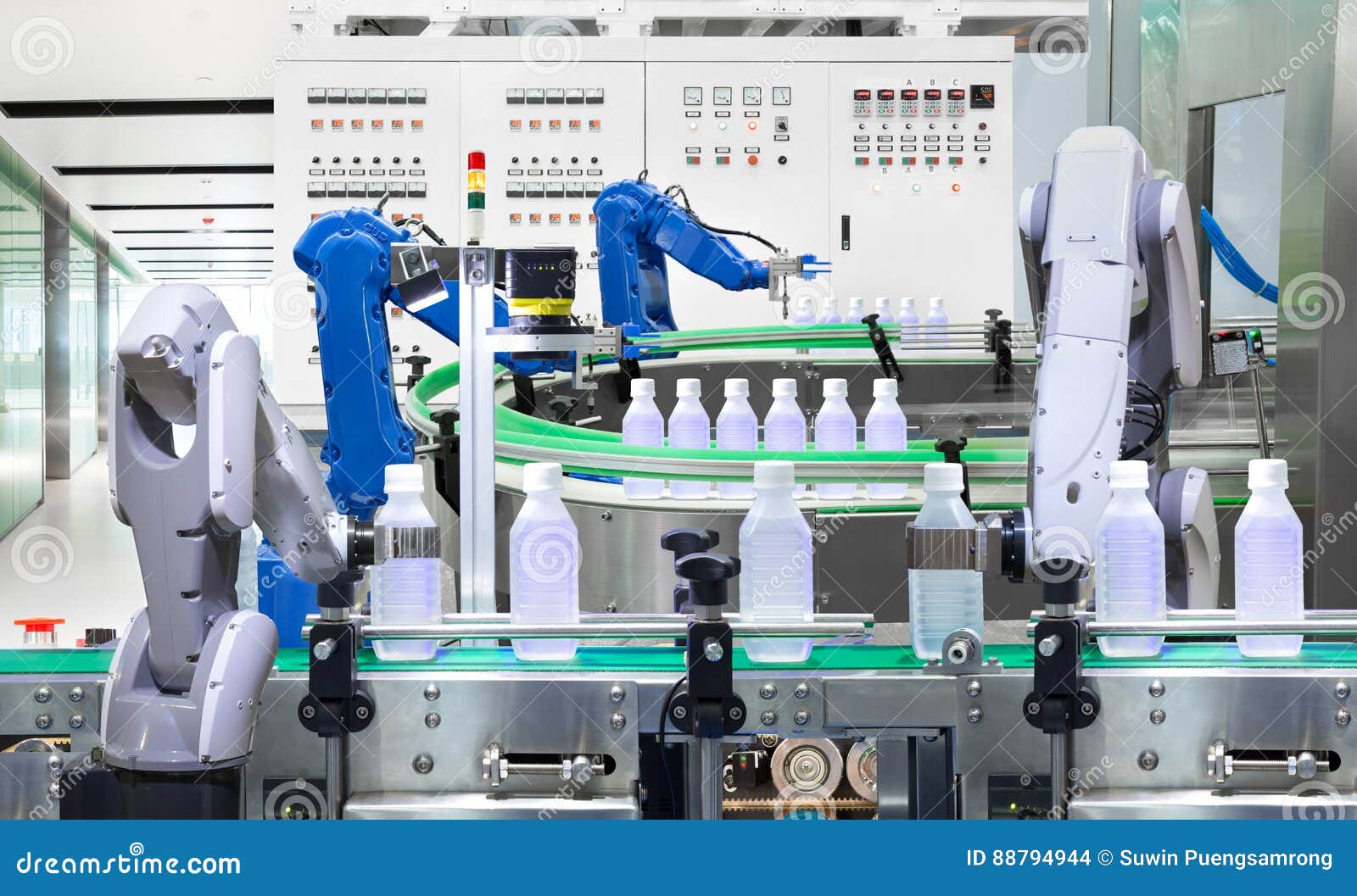 robotic arm holding water bottles on production line in factory, industry 4.0 concept