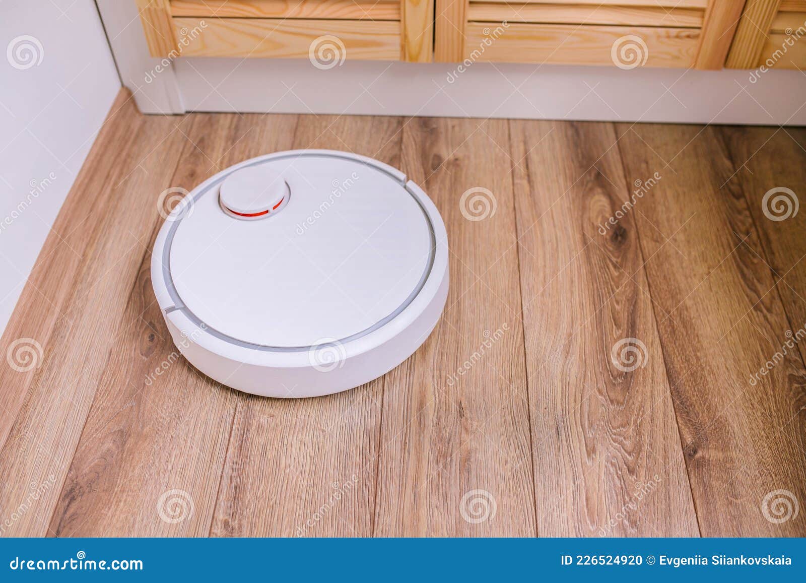 Robotic Vacuum Cleaner in the Corner of the Room. Stock Photo Image