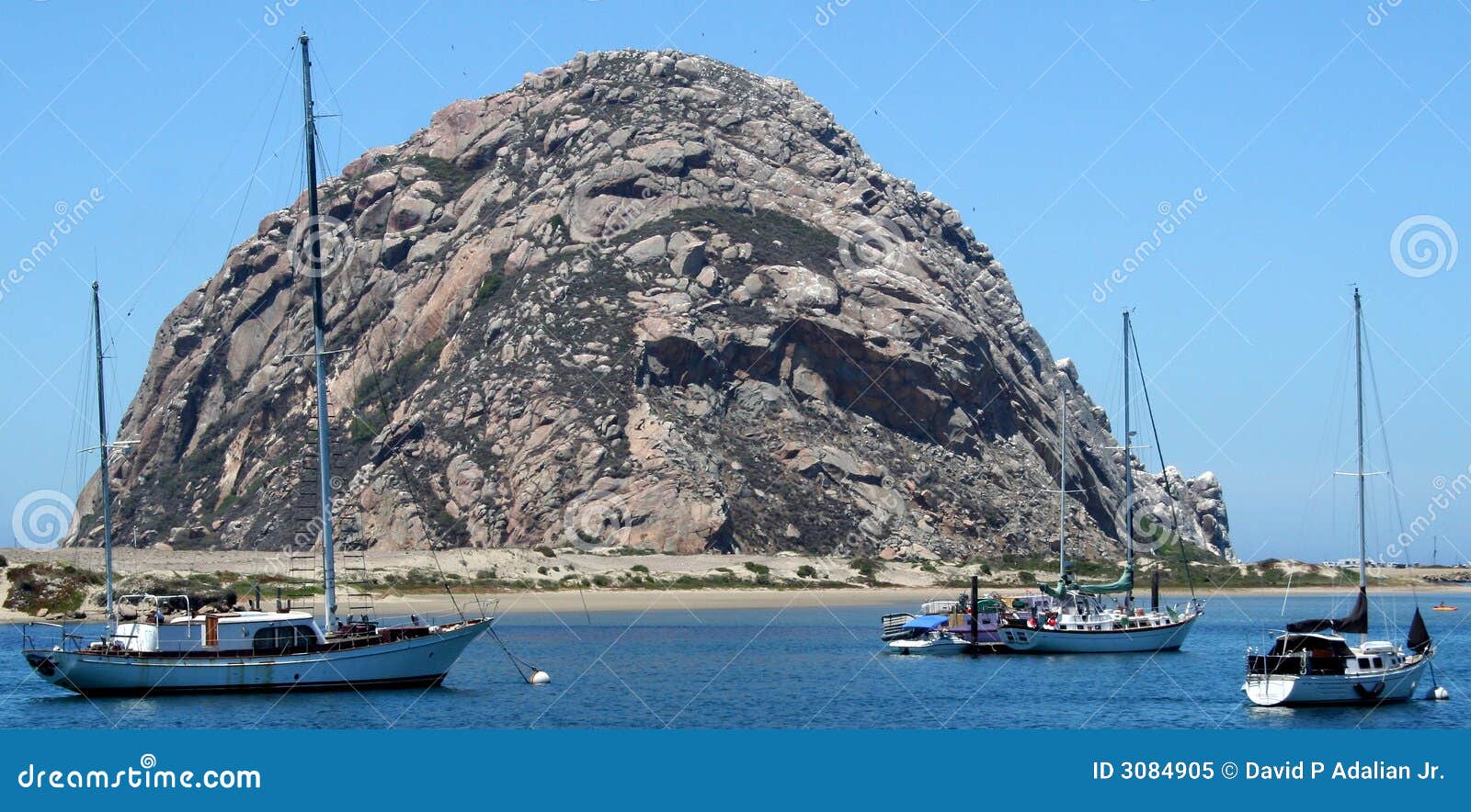 Rocha de Morro com barcos. A rocha central de Morro do marco de Califórnia domina o porto no louro de Morro, Califórnia, com os sailboats amarrados no primeiro plano.