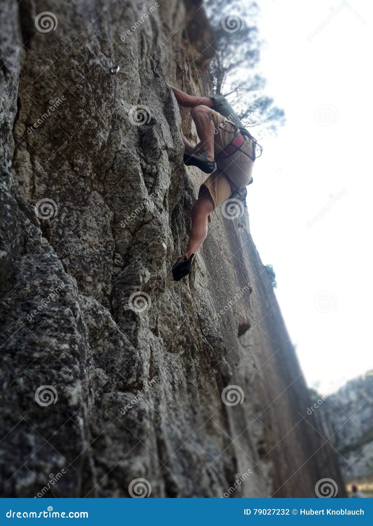 Rock Climber Climbing Granite Wall Shot from Underneath Stock Photo
