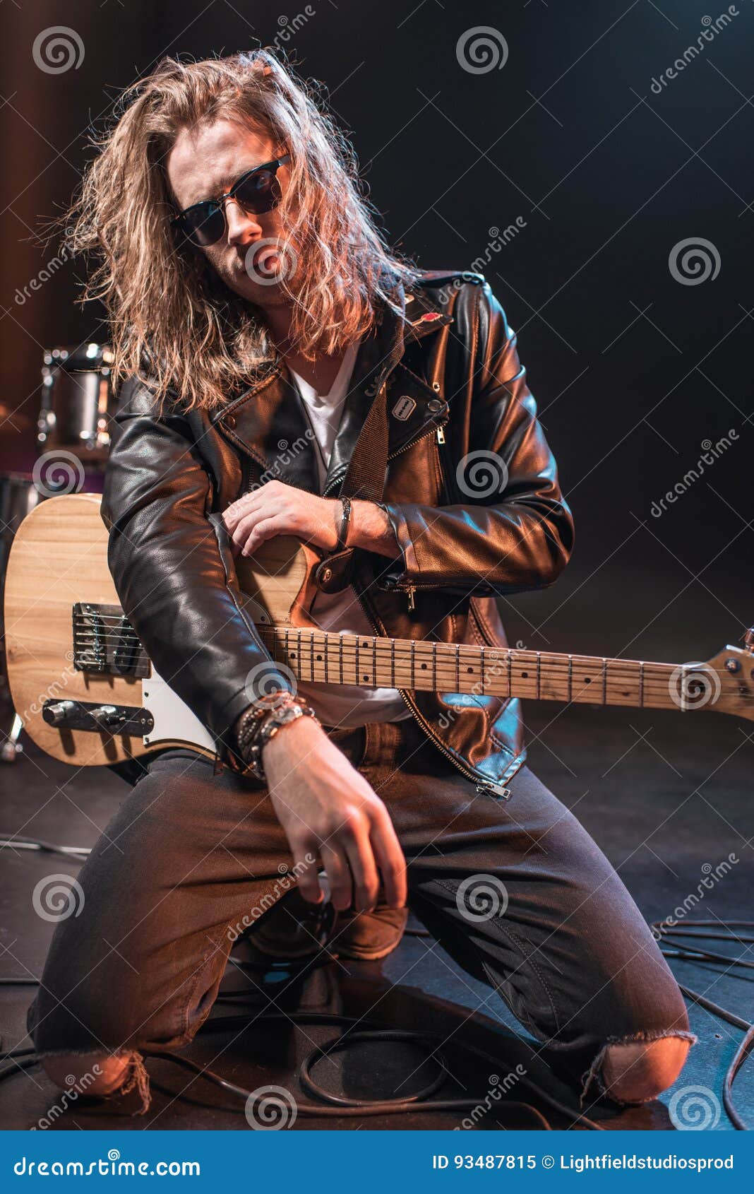 Rock Star in Eyeglasses Posing with Electric Guitar on Stage Stock