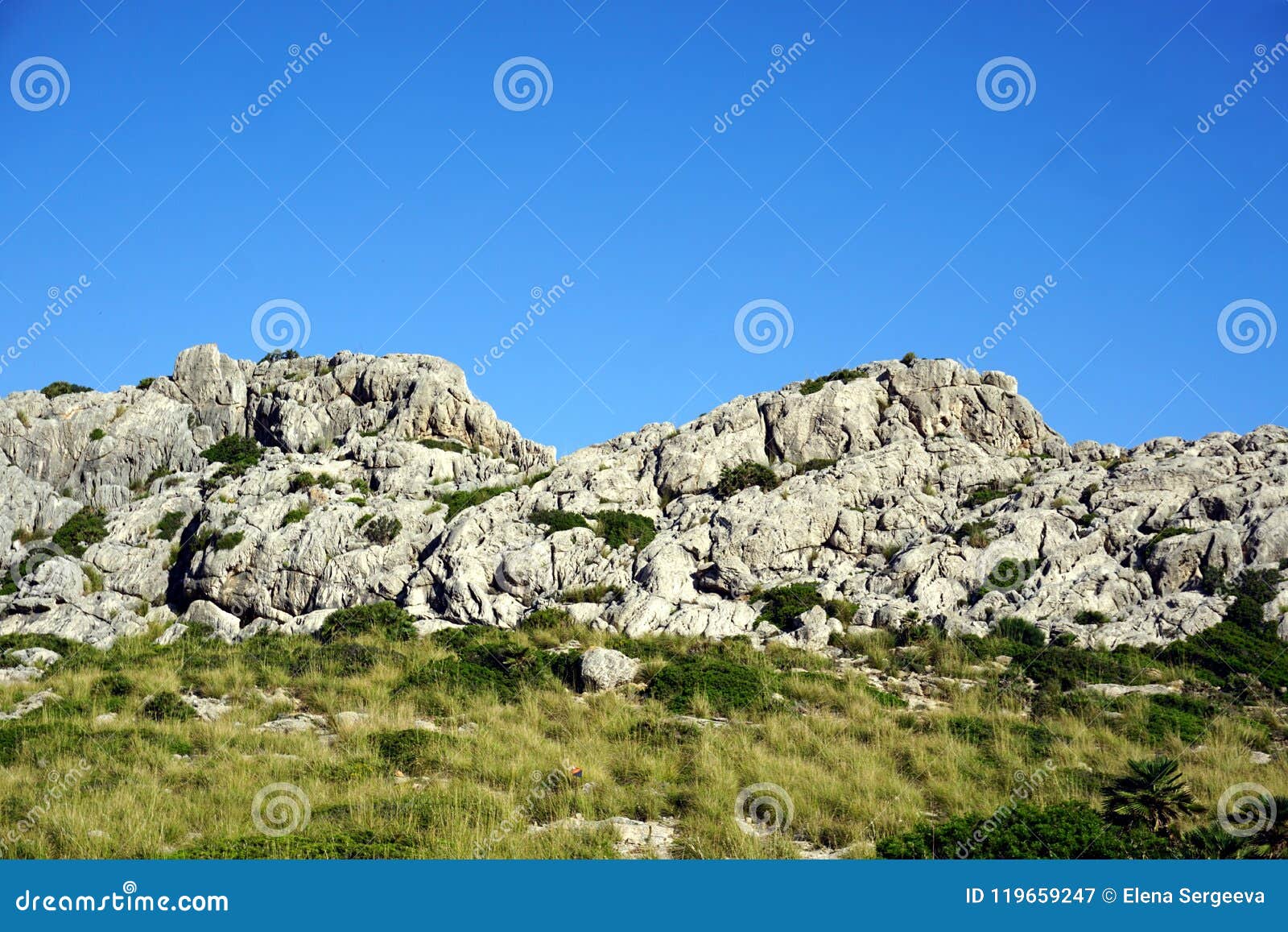 rocks and clear the blue sky and green grass