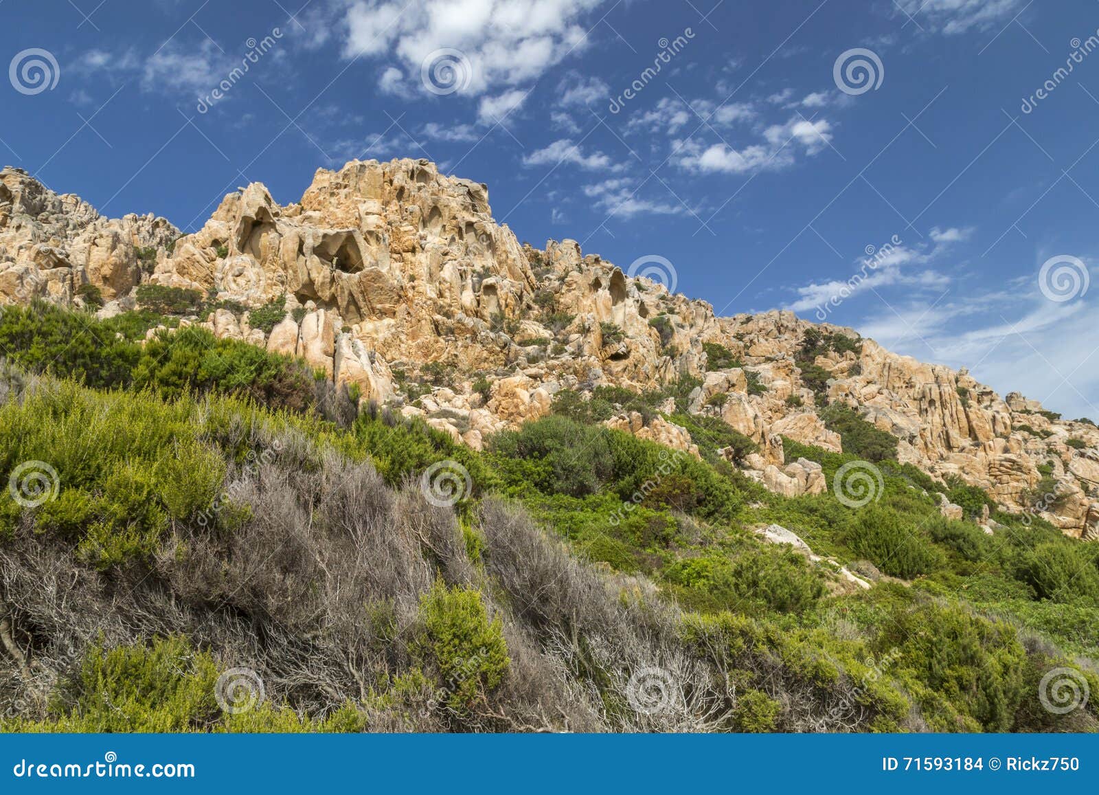 rocks and mountains behing bay of cala coticcio in caprera island, sardinia, italy