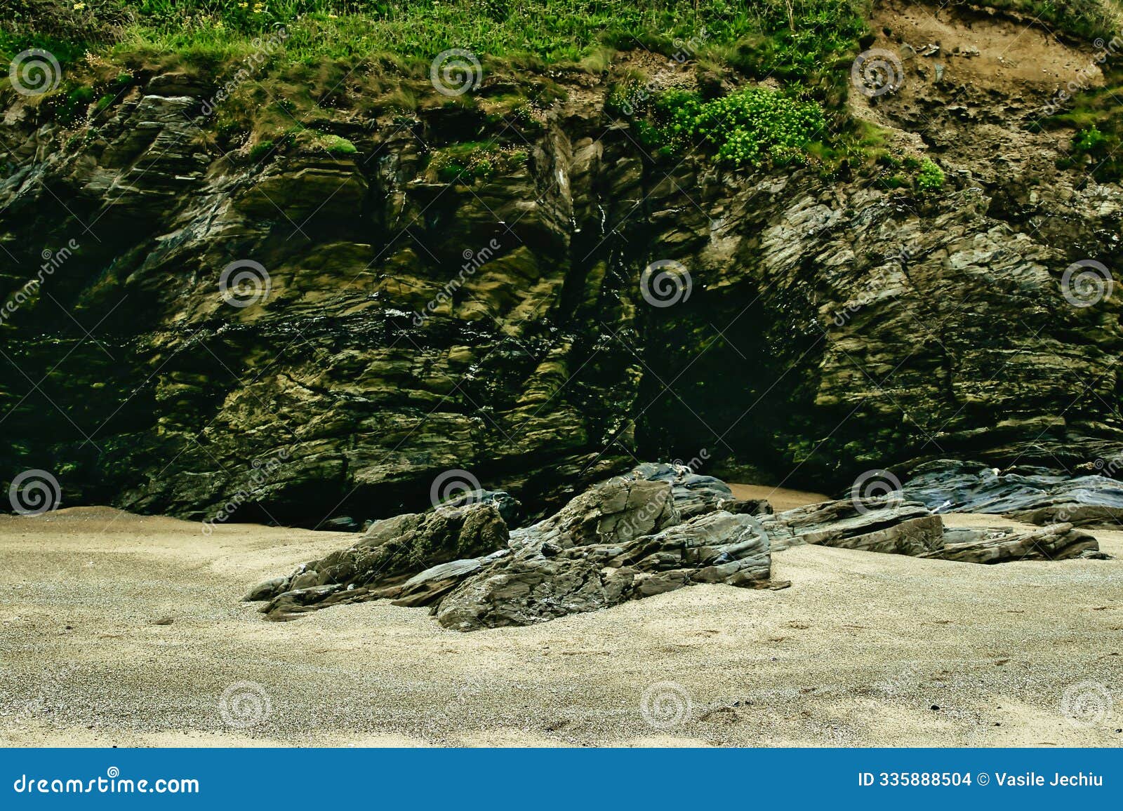 rocky beach with cliffs and greenery at mawgan porth beach, newquay, cornwall