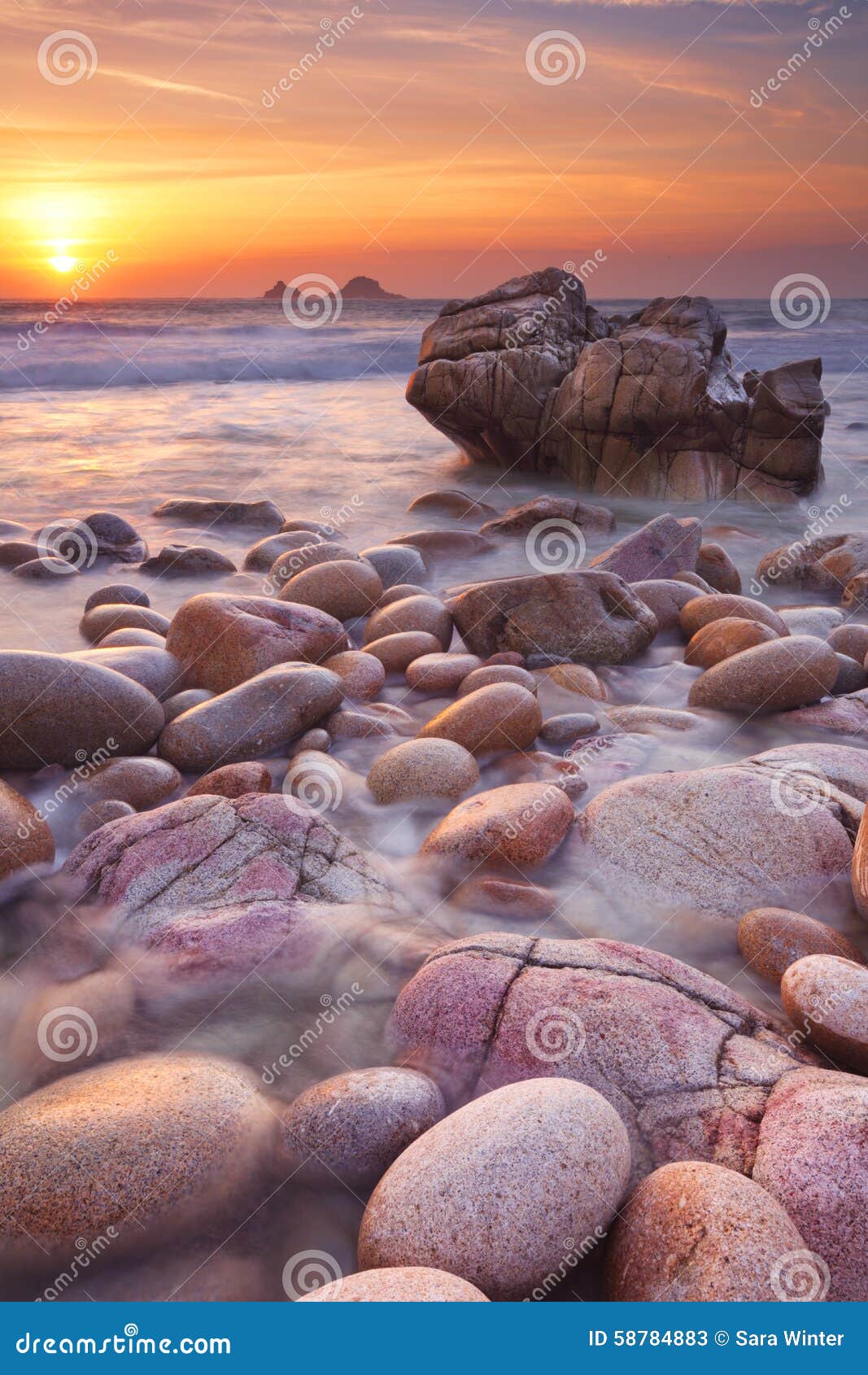 rocky beach at sunset in cornwall, england