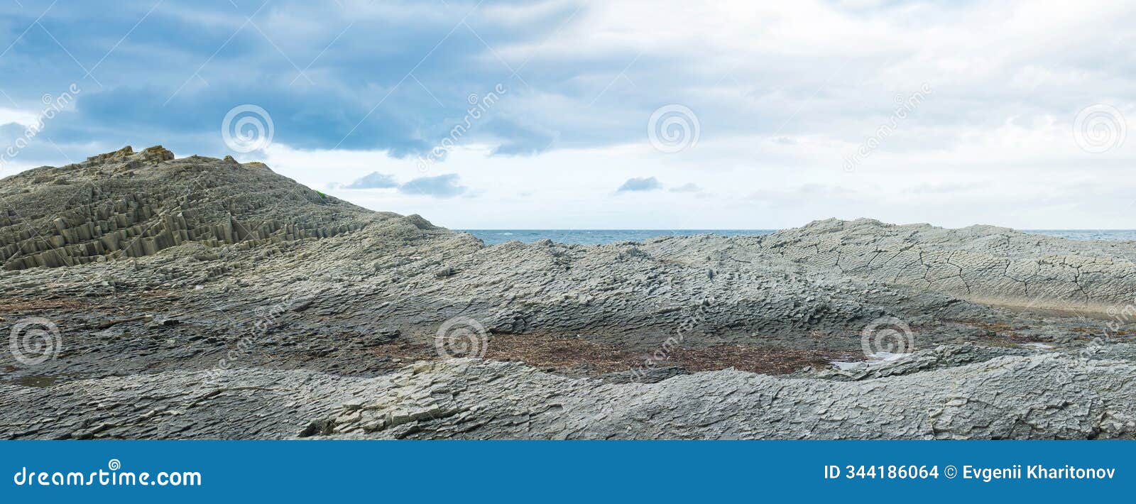 rocky seashore made of columnar granite, hardened lava, resembling scales or cobblestone pavement, coast of kunashir island