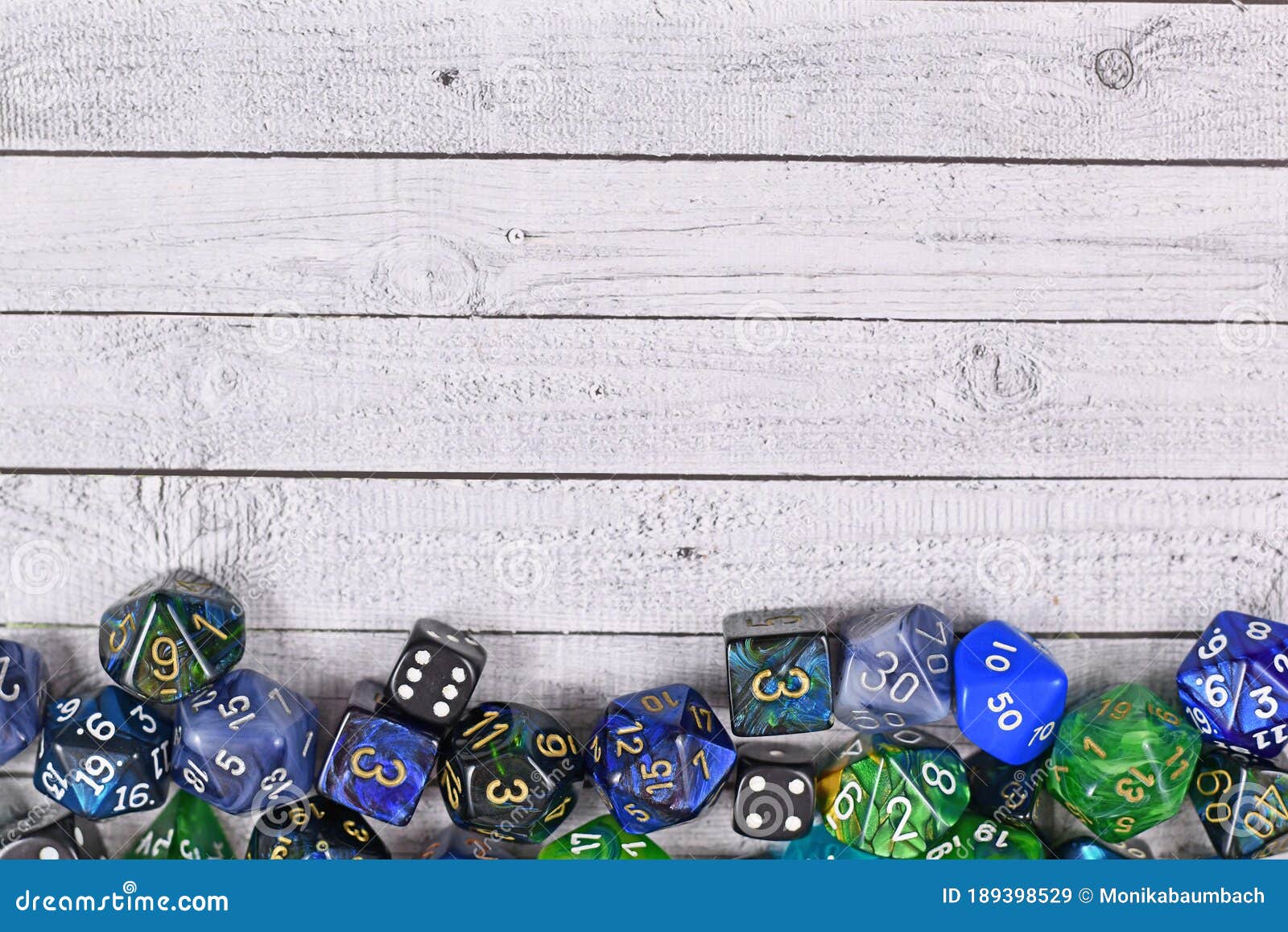 roleplay game background with different blue and green rpg dices at bottom of wooden table background with copy space