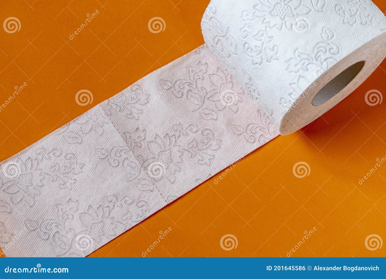 A Roll of Toilet Paper on a Orange Table. Close Up Stock Photo Image