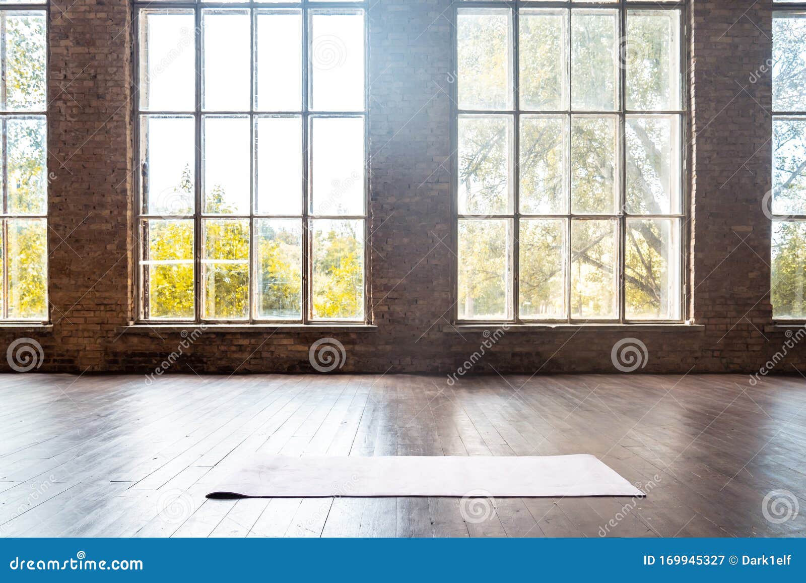 rolled yoga pilates rubber mat inside gym studio on wooden floor background