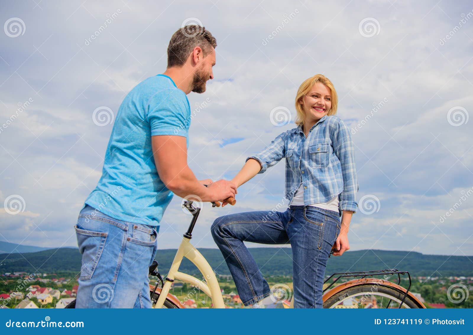 rolling romance or bike date. man with beard and shy blonde girl on first date. woman feels shy in company with