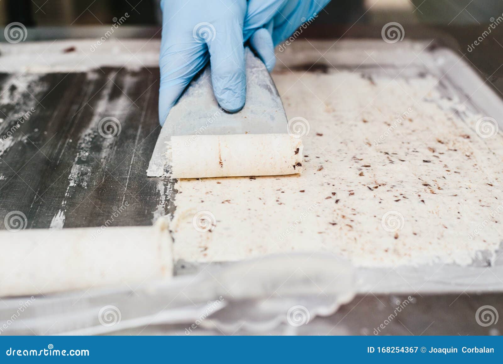 rolling a white ice cream to prepare a cup of chocolate-wrapped ice cream