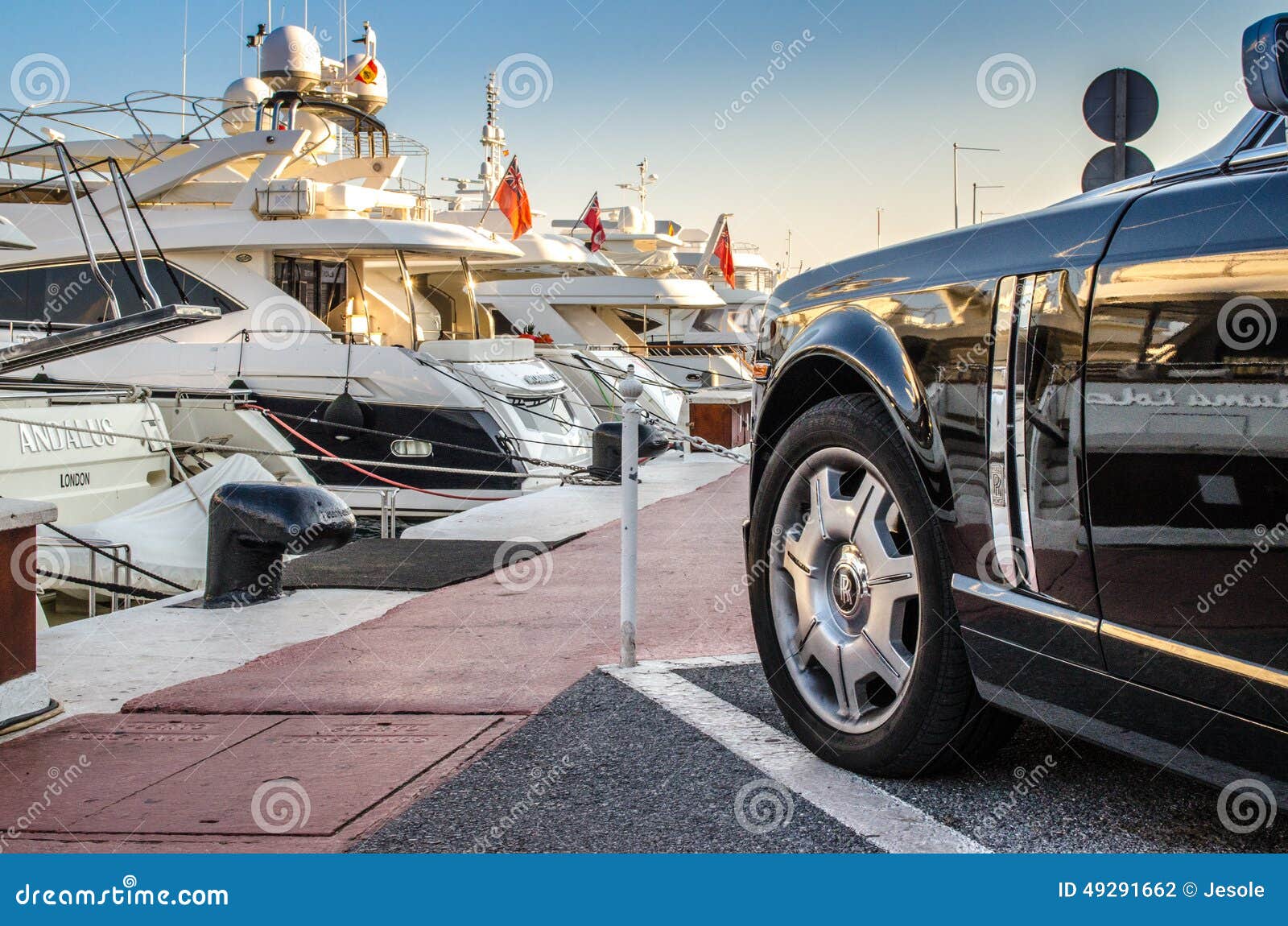 Sports cars parked next to yachts in the Luxury marina of Puerto