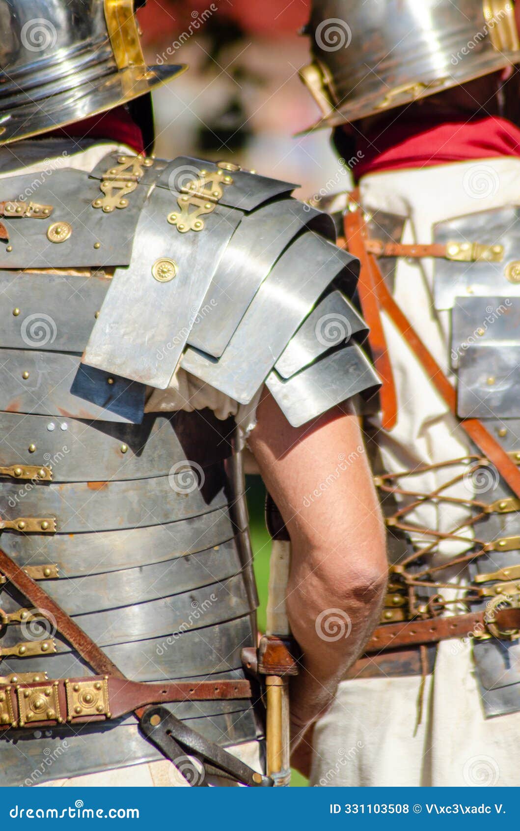 roman legionaries in metal armor at a historical reenactment event seen from behind