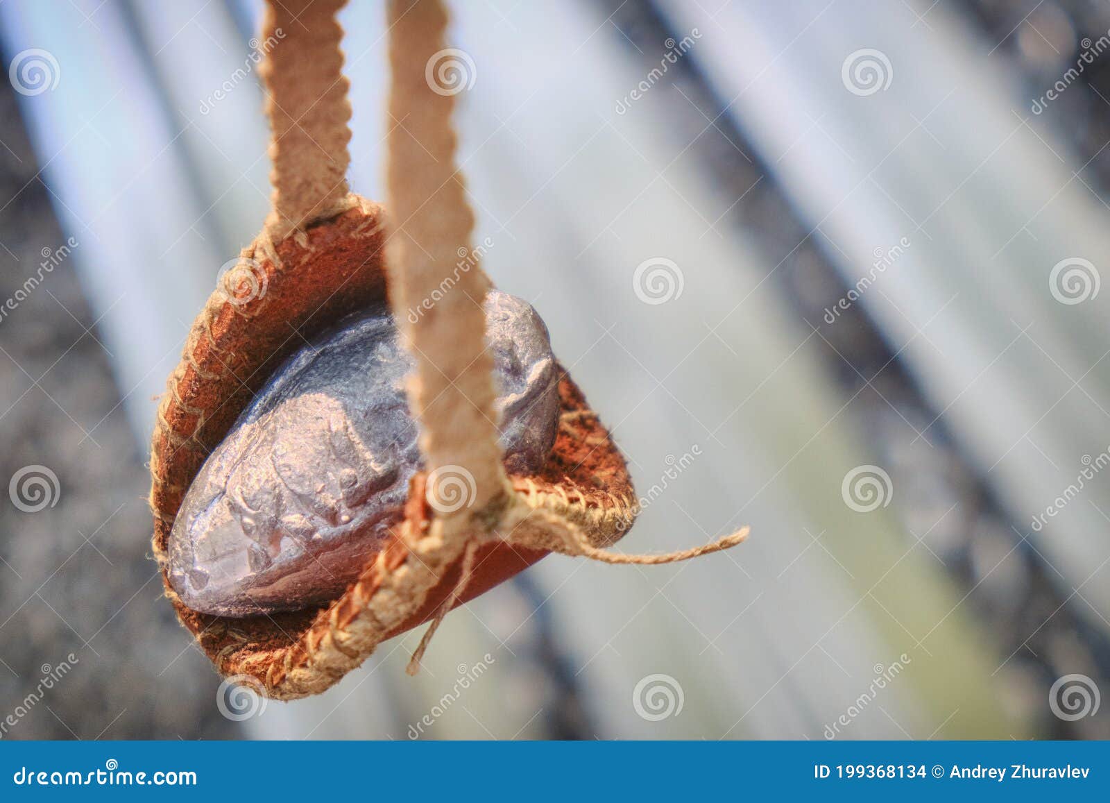 Roman Slingshot of Leather on the Background of Chain Mail