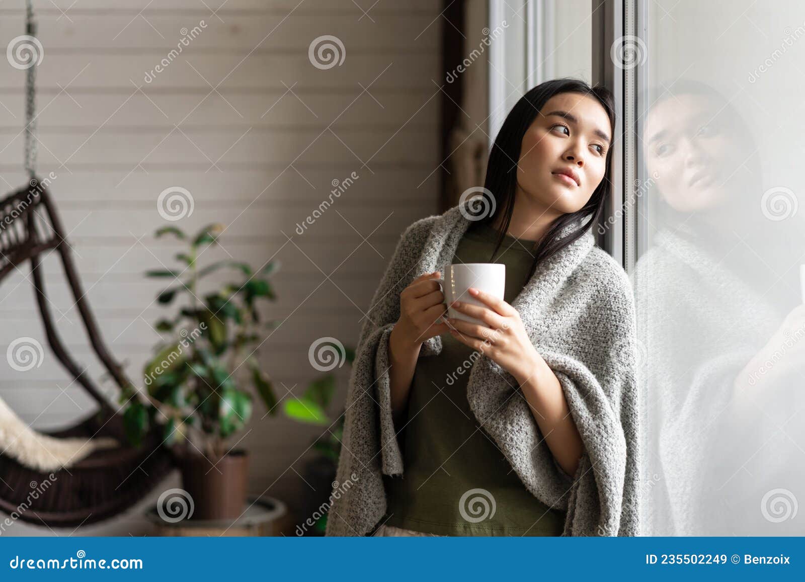 Romantic Asian Woman Wrapped in Blanket, Leaning on Window and Looking ...