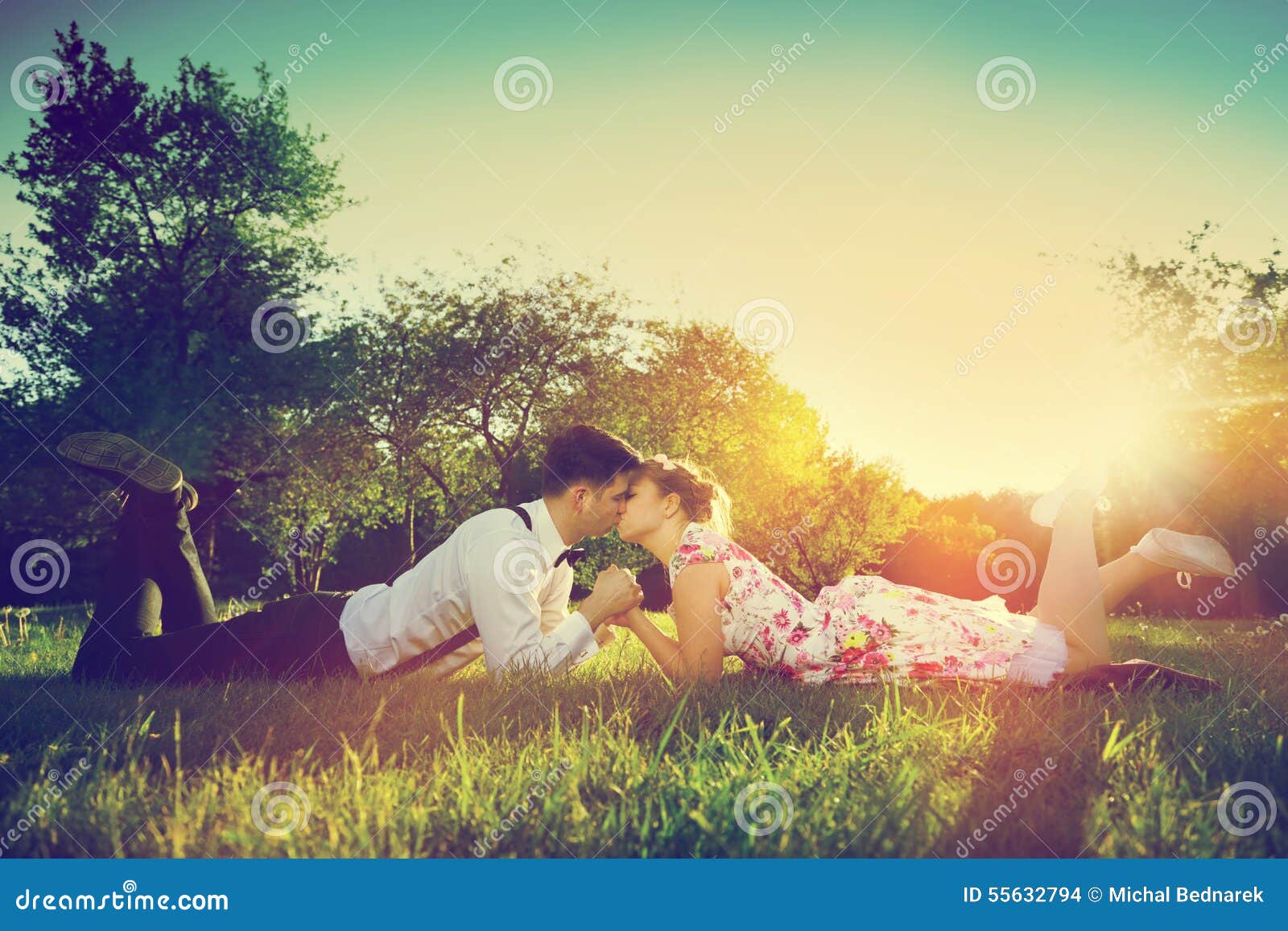 romantic couple in love kissing while lying on grass. vintage