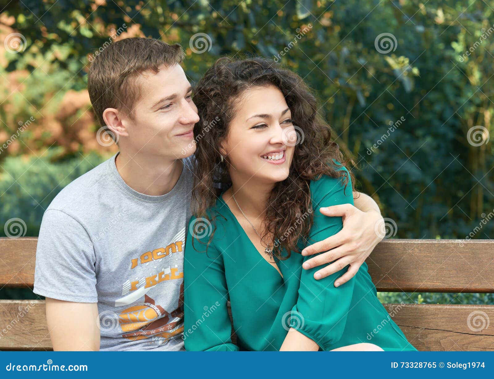 Studio shot of romantic couple posing with smile. Front view of girl and boy  hugs on blue background. 12195201 Stock Photo at Vecteezy