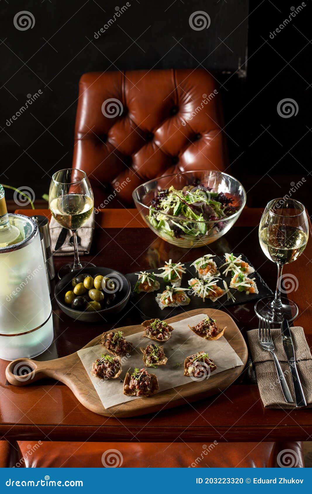 Romantic Dinner Setup with Fancy Food Appetizer and White Wine in a Restaurant Stock Photo