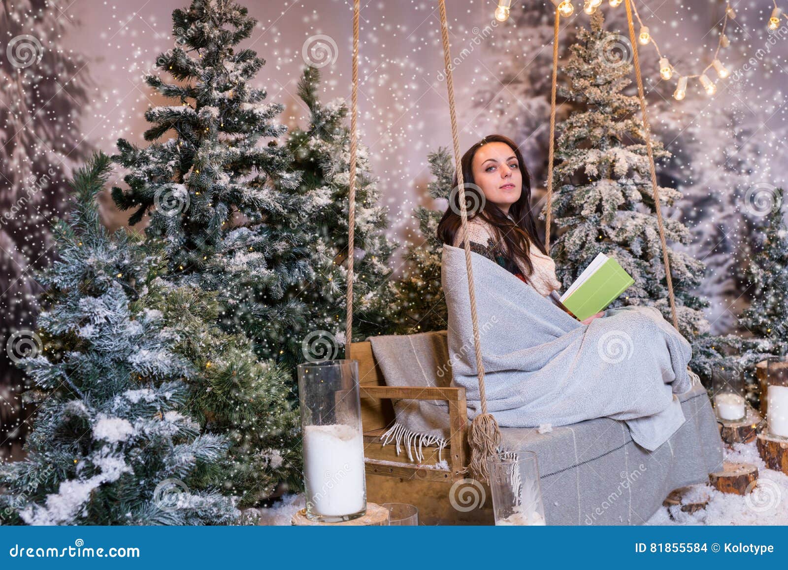 Romantic Girl Sitting on a Swing, Holding an Open Book and Wrapped in a ...