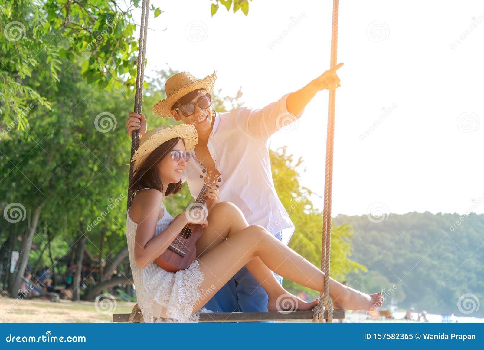 romantic lifestyle asian couples lover playing an ukulele on the hammock. relax