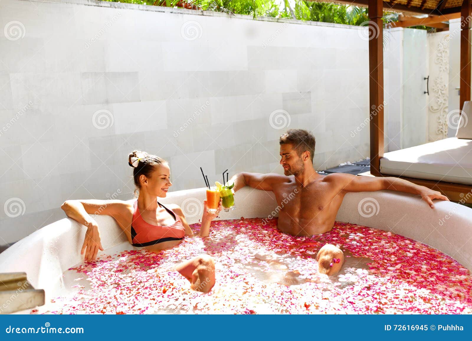 Romantic Vacation. Couple in Love Relaxing at Spa with Cocktails