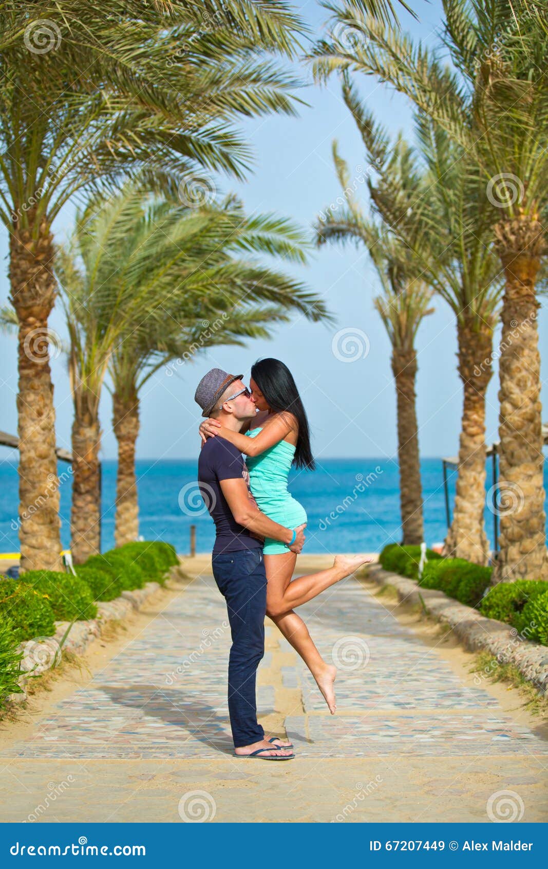 Romantyczny pary całowanie na plaży z drzewkami palmowymi
