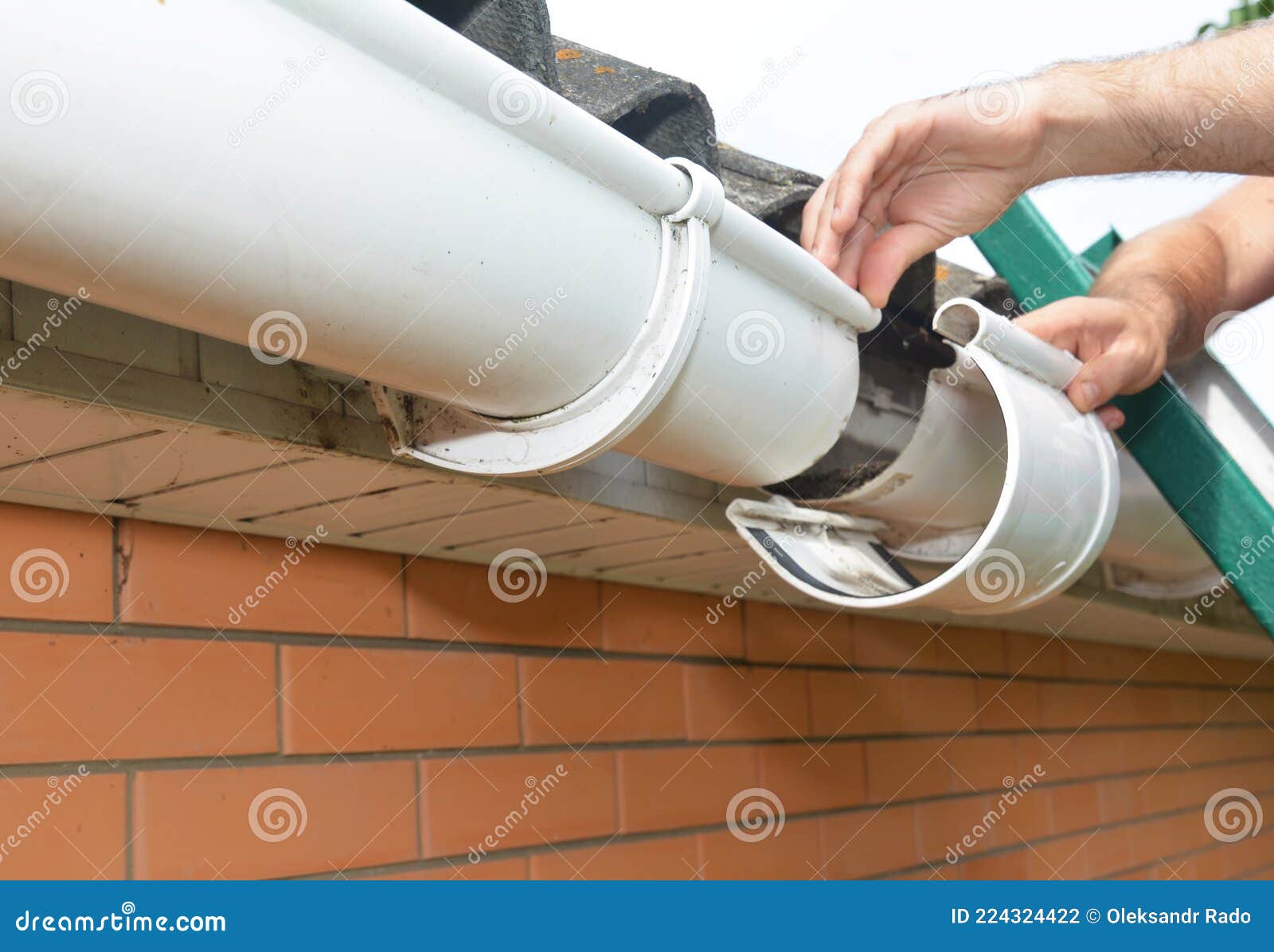 Roof Gutter Installation and Repair. a Man on a Ladder is