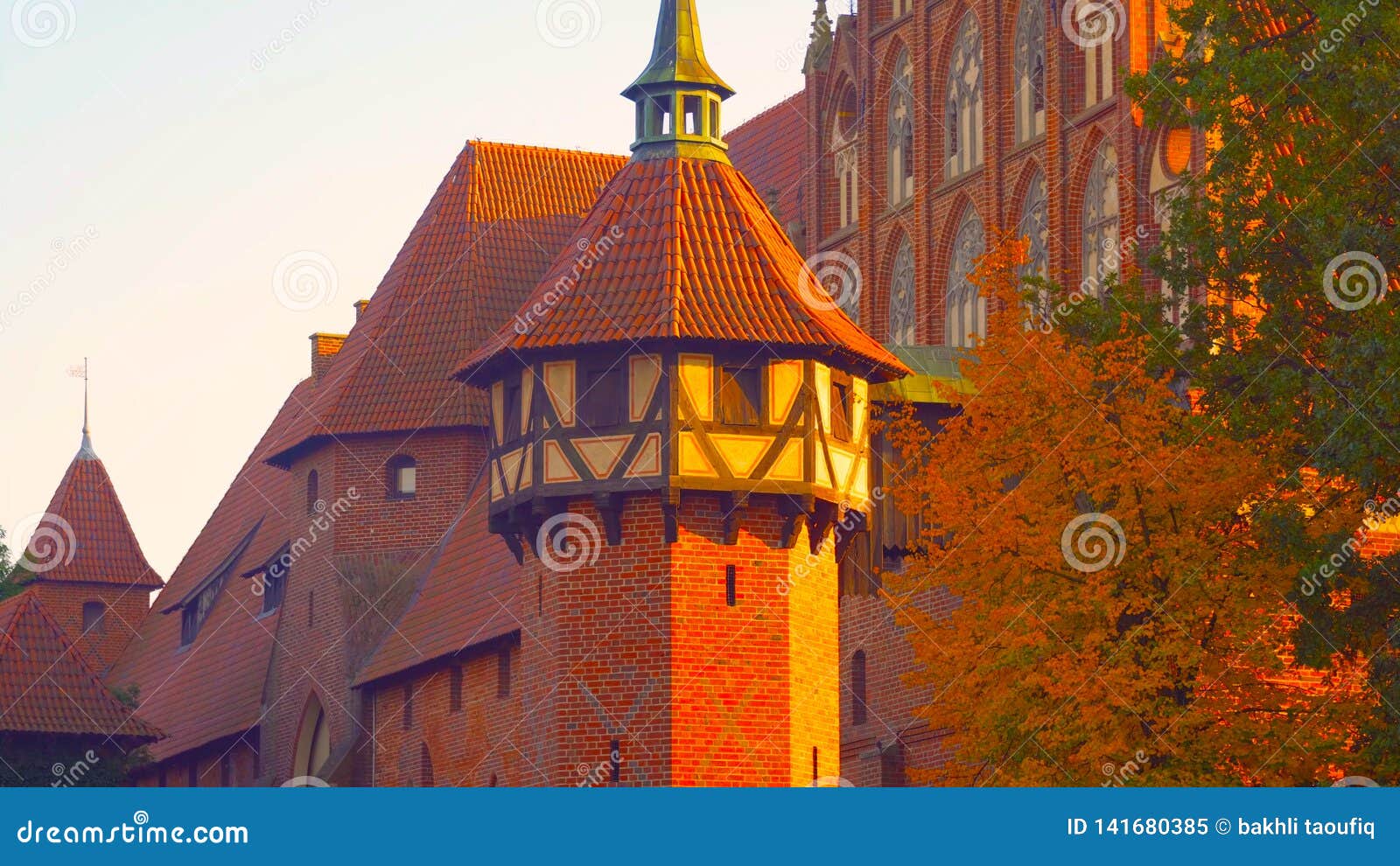 the roof of an old building in poland. the color of the wall is red in the traditional style