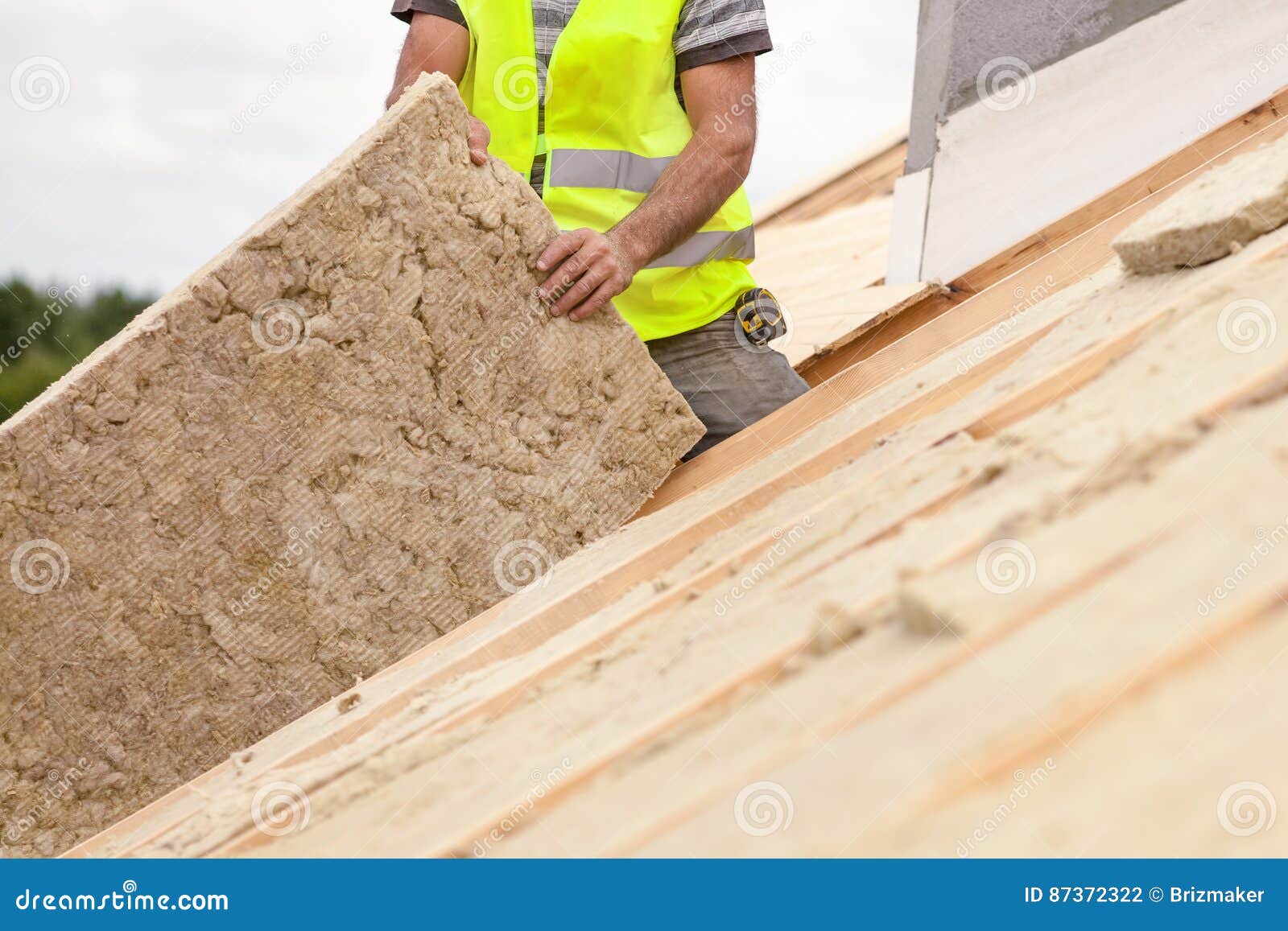Roofer Builder Worker Installing Roof Insulation Material on New House