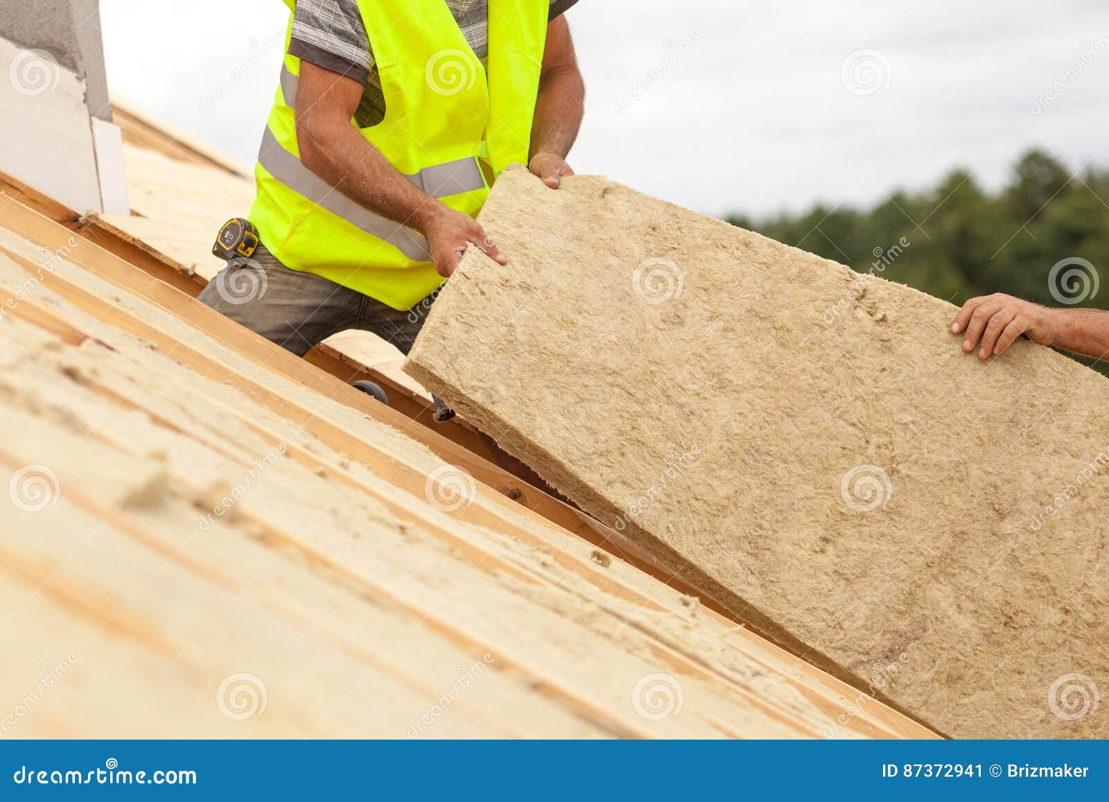 Roofer Builder Worker Installing Roof Insulation Material on New House