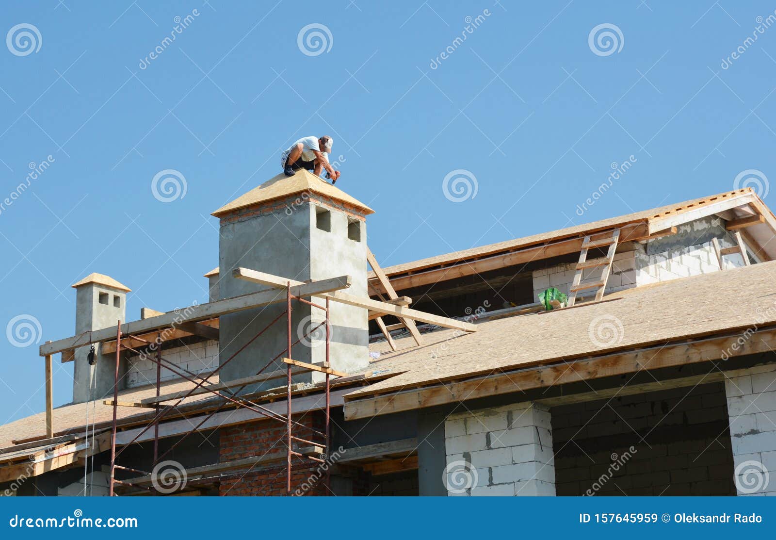 roofer contractors laying asphalt shingles on the house roof top. house roofing constuction with asphalt shingles